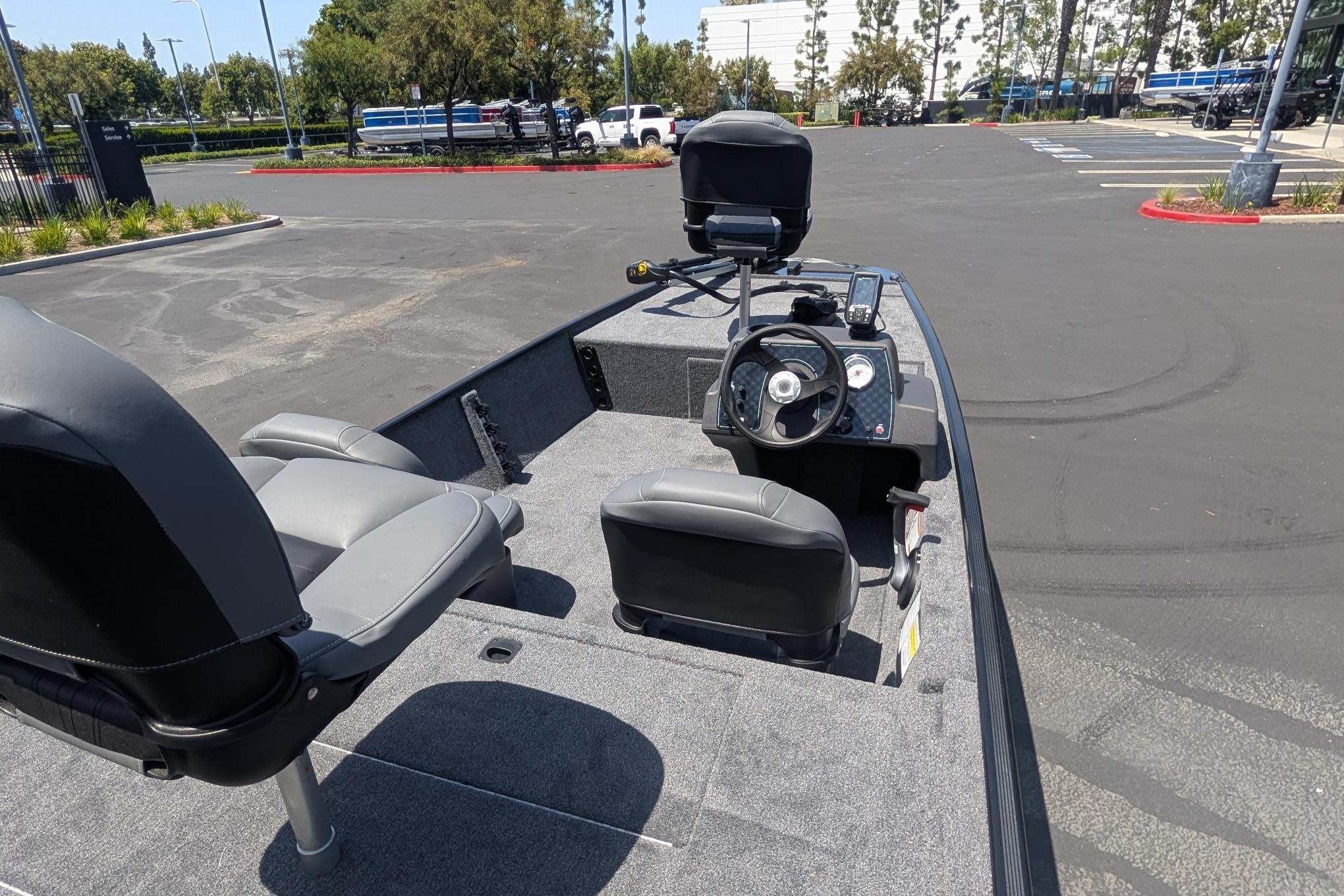 2026 Tracker Bass Tracker Classic XL boat with seating and steering wheel in a parking lot.