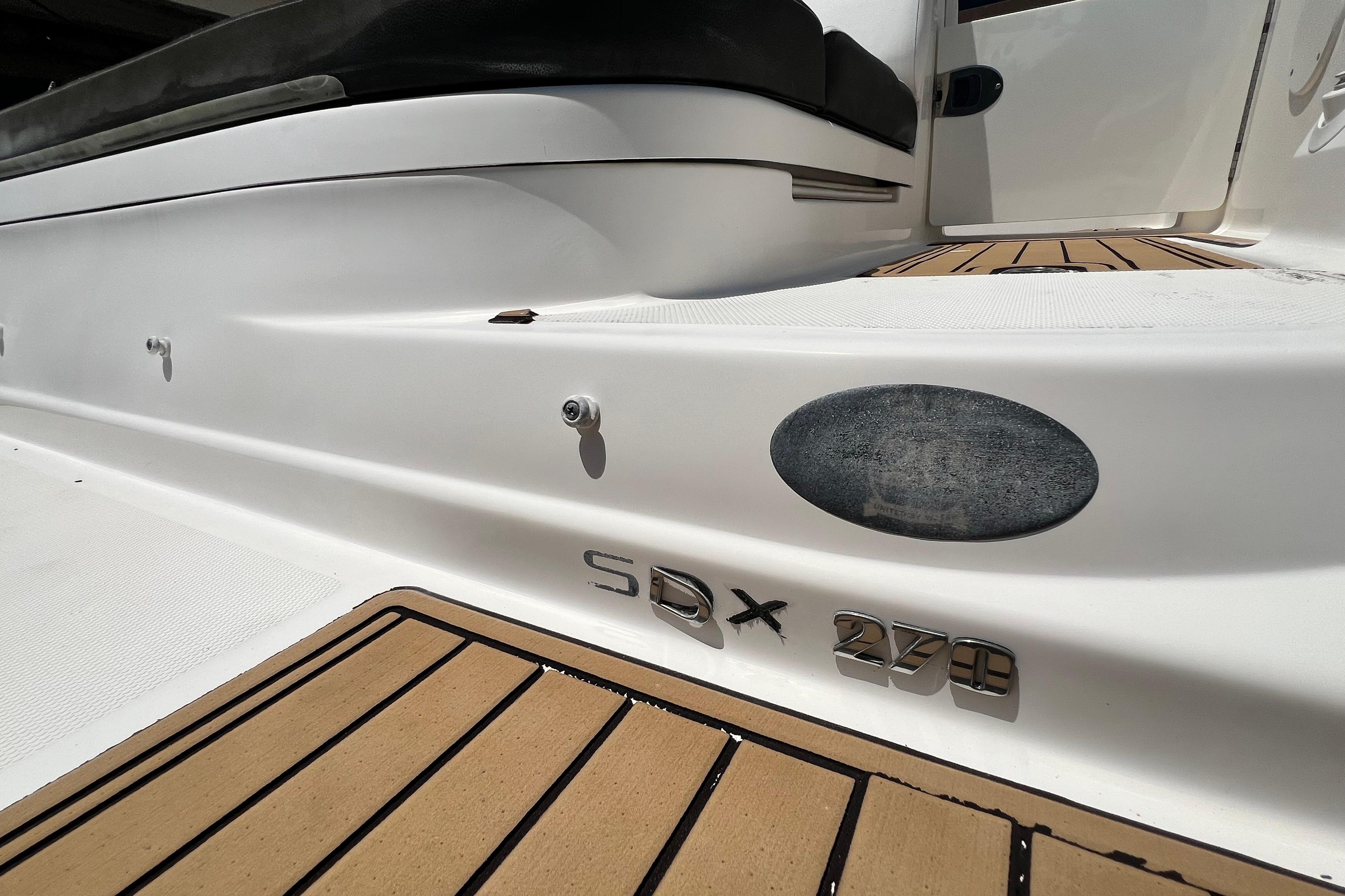 2019 Sea Ray SDX 270 Outboard boat deck with teak flooring and model emblem.