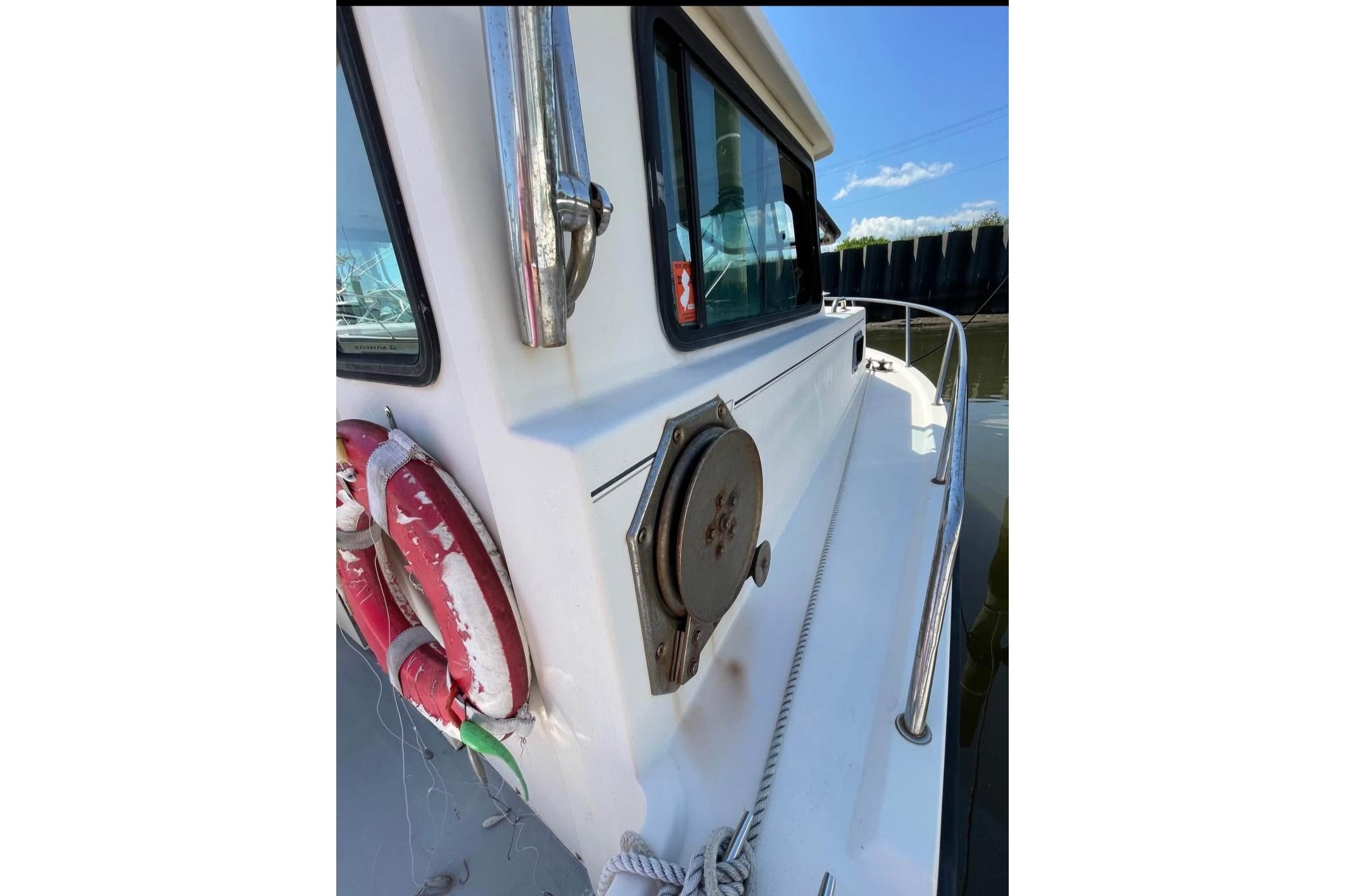 2002 Parker 2520 Deep Vee Sport Cabin boat with life rings and railing.