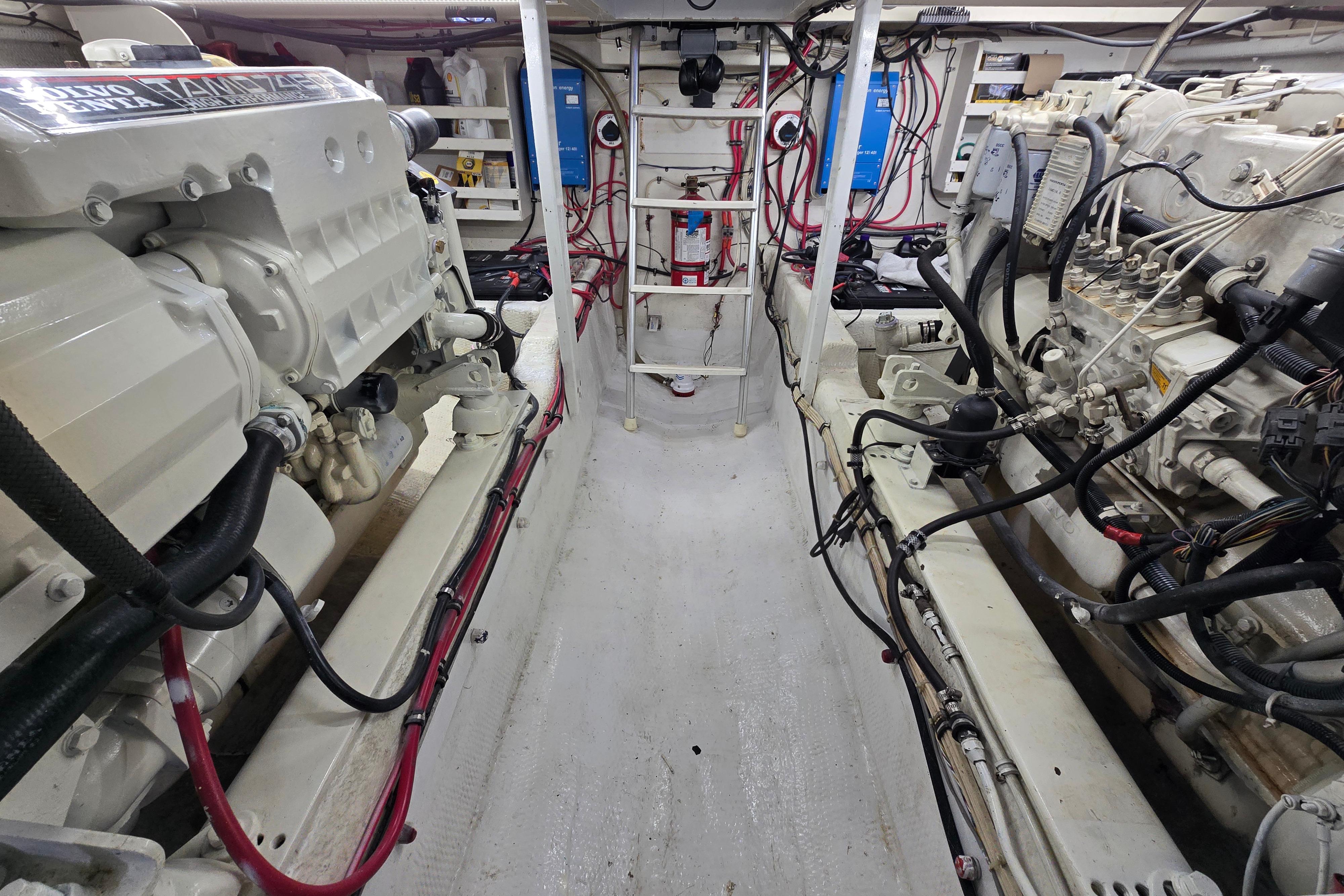 Engine room of 2000 Custom 42 JM Sportfish boat, featuring dual engines and wiring.