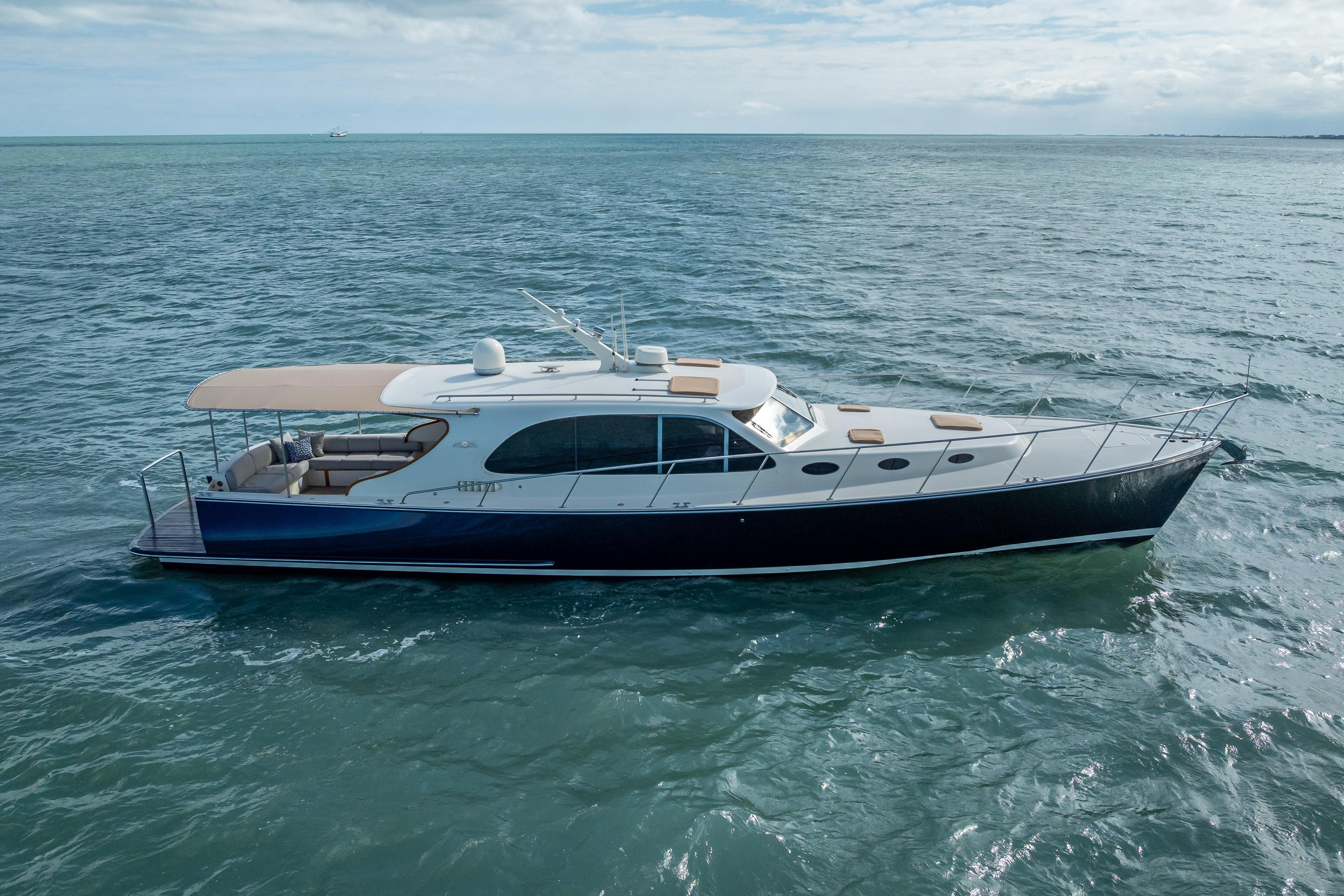 2018 Palm Beach Motor Yachts PB50 cruising on open water under a cloudy sky.
