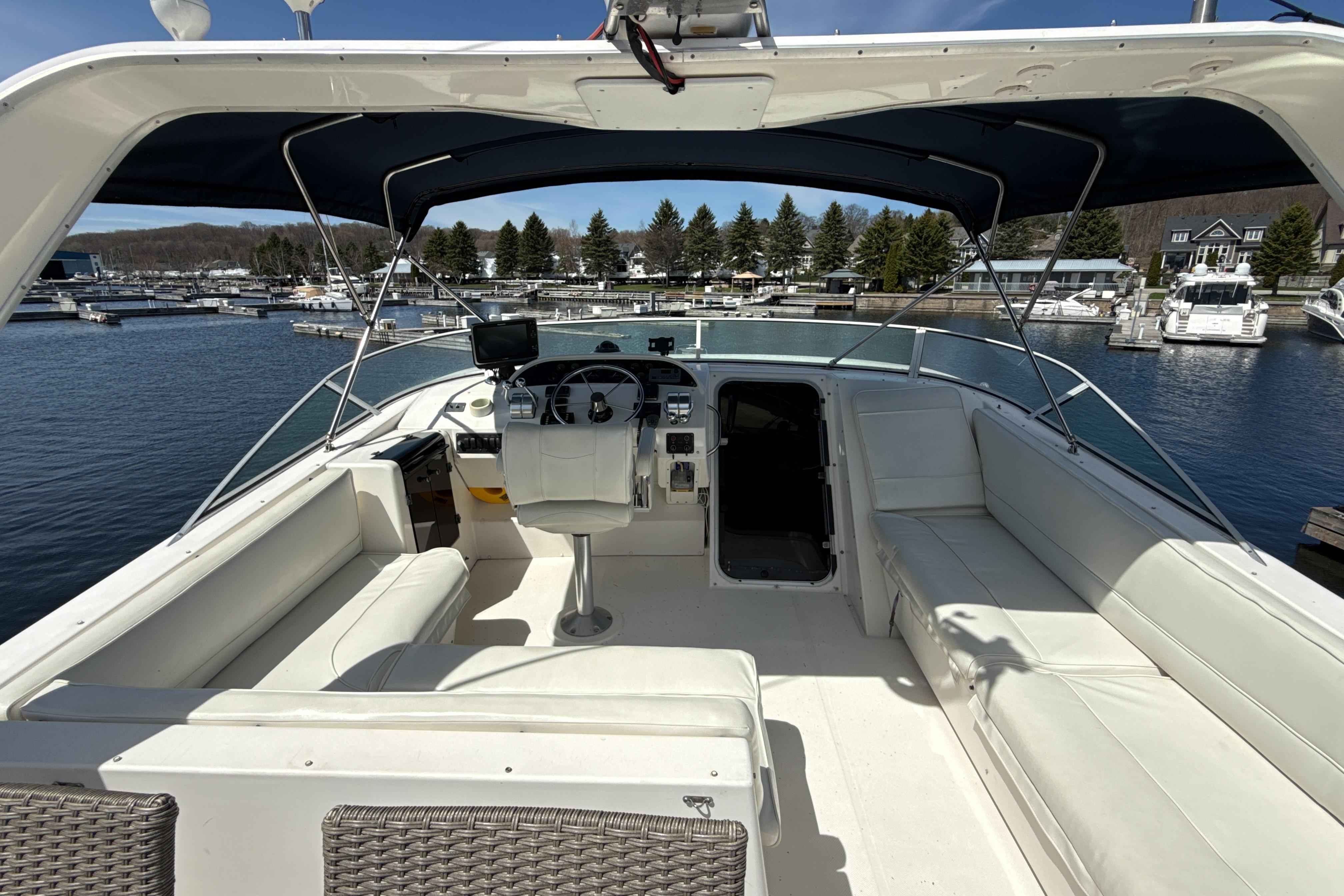 1997 Bayliner 4788 Pilot House Motoryacht interior with helm, seating, and marina view.