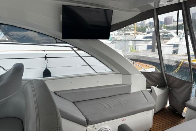 Interior of 2013 Beneteau Gran Turismo 38 yacht with seating and mounted TV.