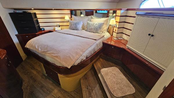 Luxurious bedroom in 2005 Neptunus 56 Flybridge yacht with elegant wood accents.