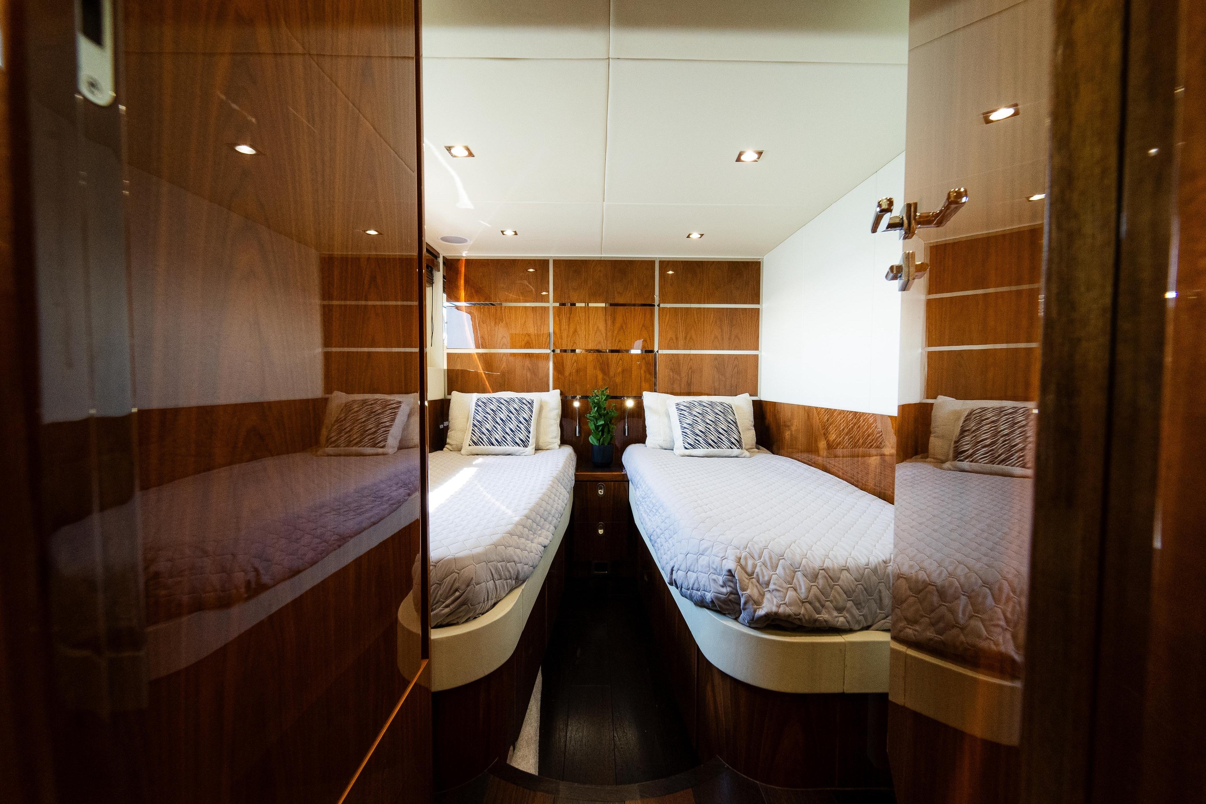 Luxurious twin cabin interior of 2016 Sunseeker Manhattan 65 yacht with wood paneling.