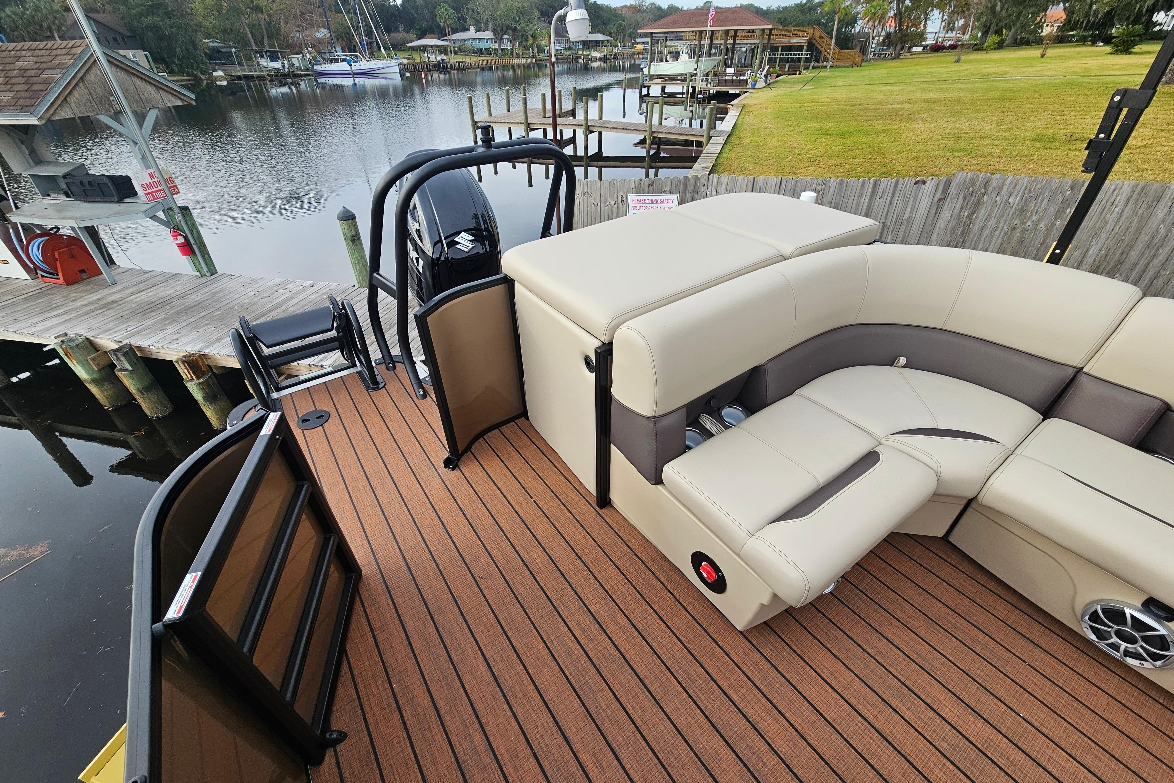 2026 Bentley Pontoons Legacy 243 Cruise with luxurious seating, docked by a serene waterfront.