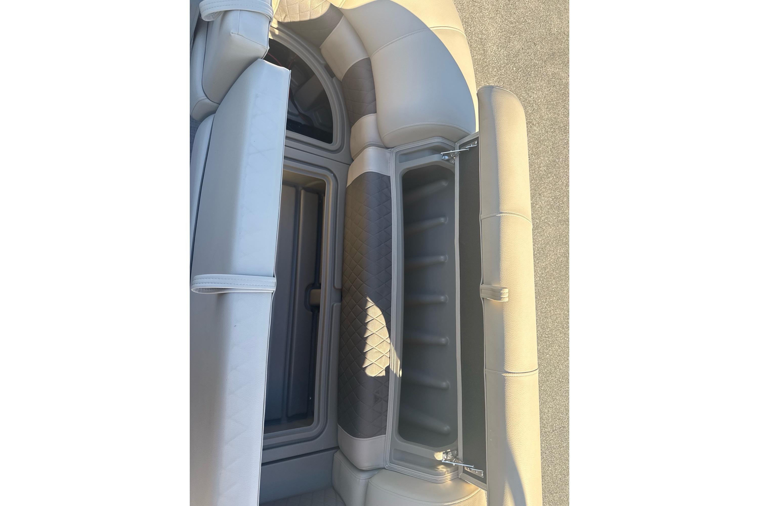 2025 Sun Tracker SportFish 22 DLX boat seating with storage compartment open.
