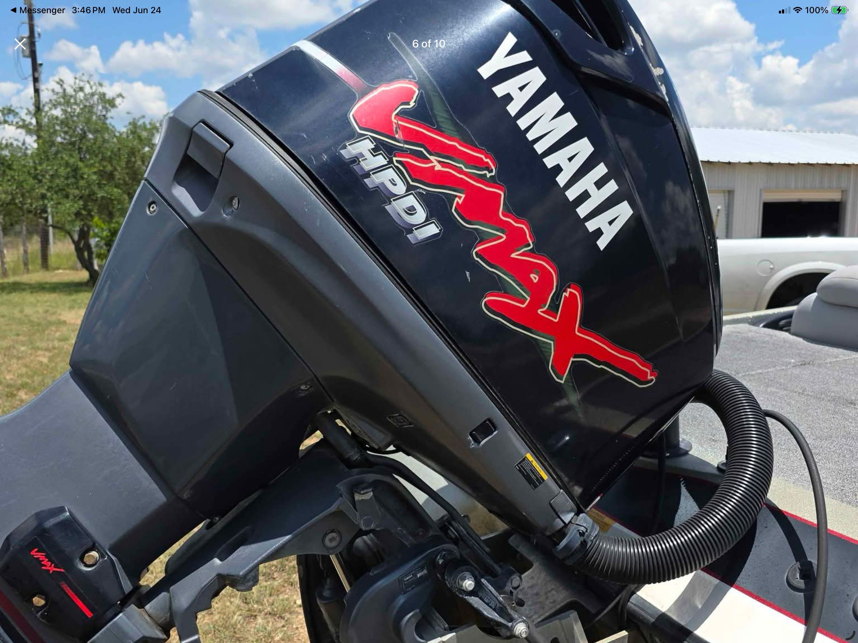 Yamaha Vmax HPDI outboard motor mounted on a boat, with a building in the background.