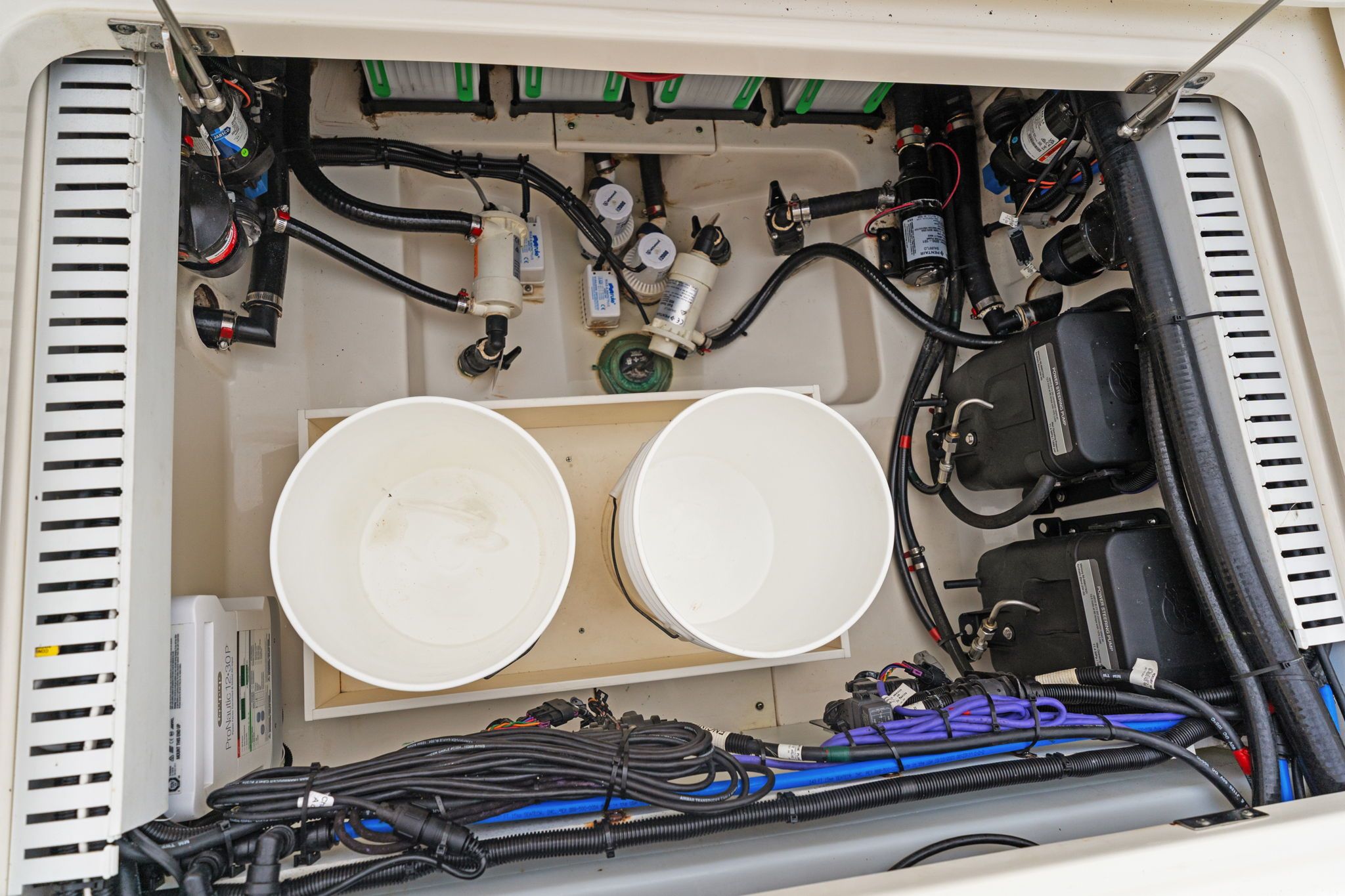 Engine compartment of 2022 Boston Whaler 330 Outrage with cables and components.