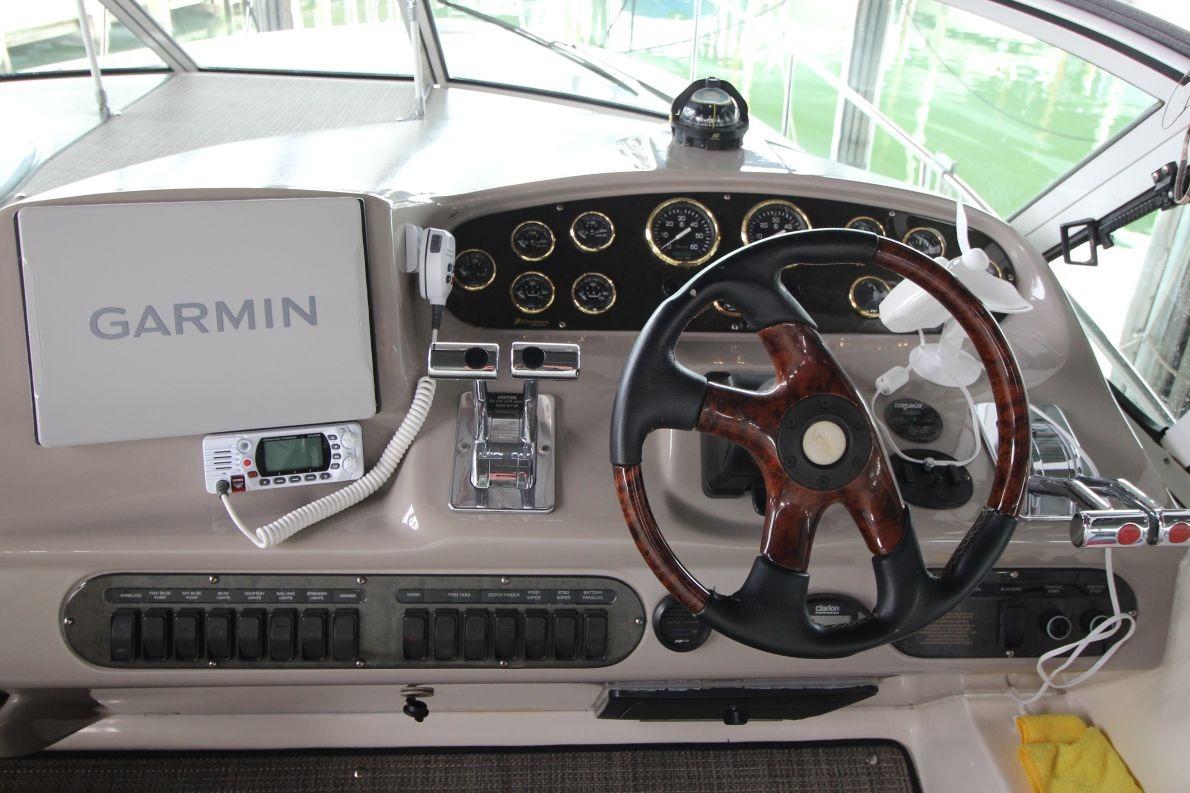 Helm of 2004 Cruisers Yachts 320 Express with Garmin navigation system and wood-accented steering wheel.