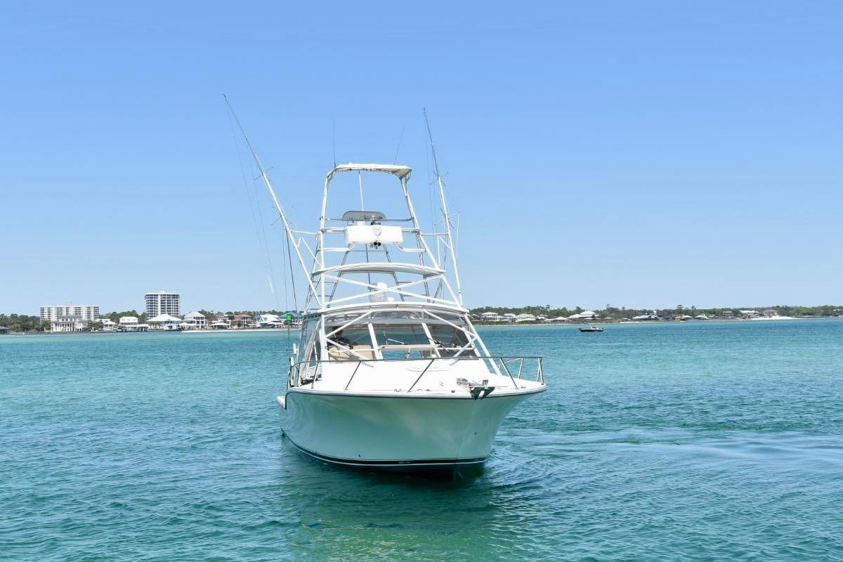 2006 Carolina Classic 32 boat on clear blue water with coastal skyline.