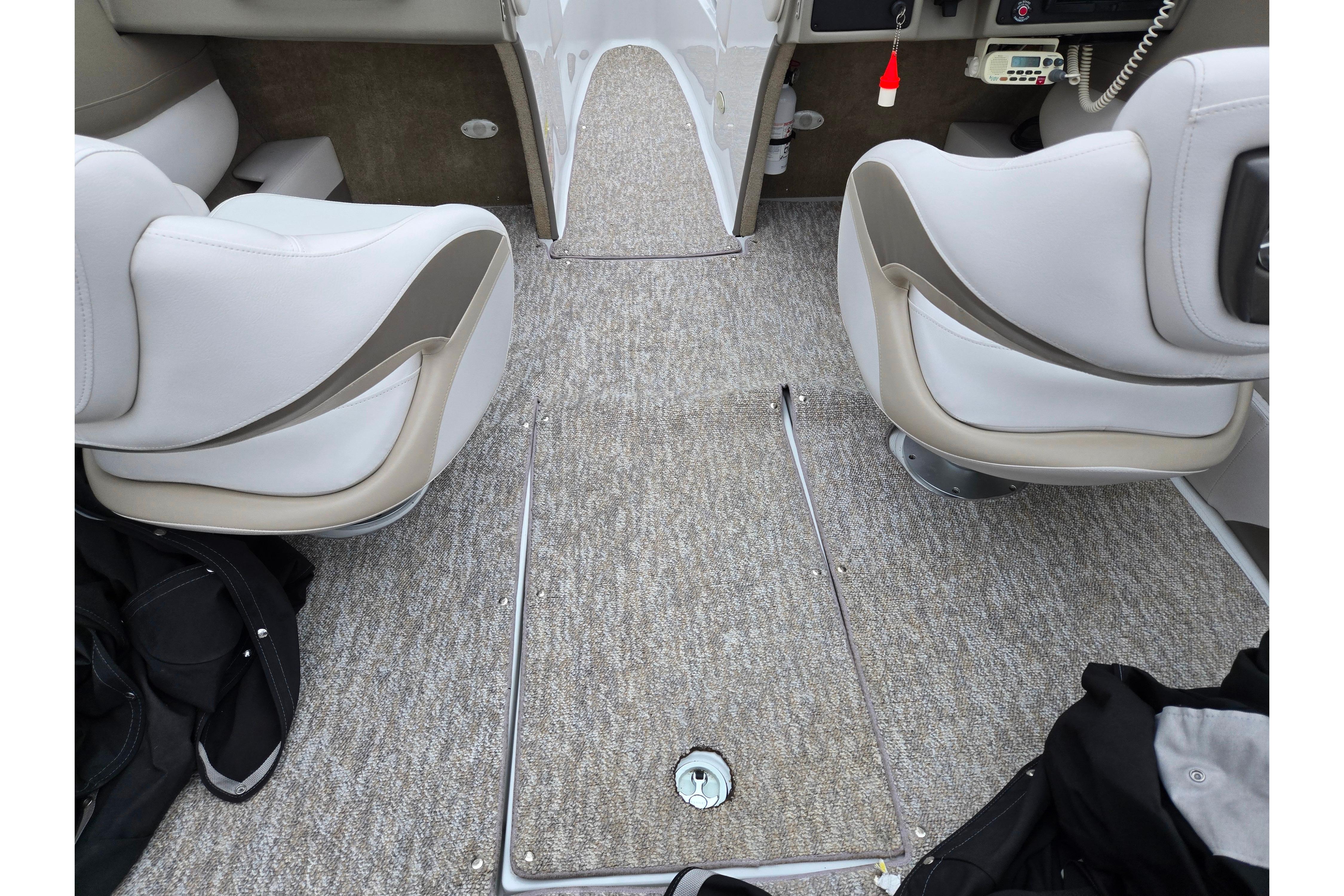 Interior of 2012 Crownline 235 SS boat with beige seating and carpeted flooring.