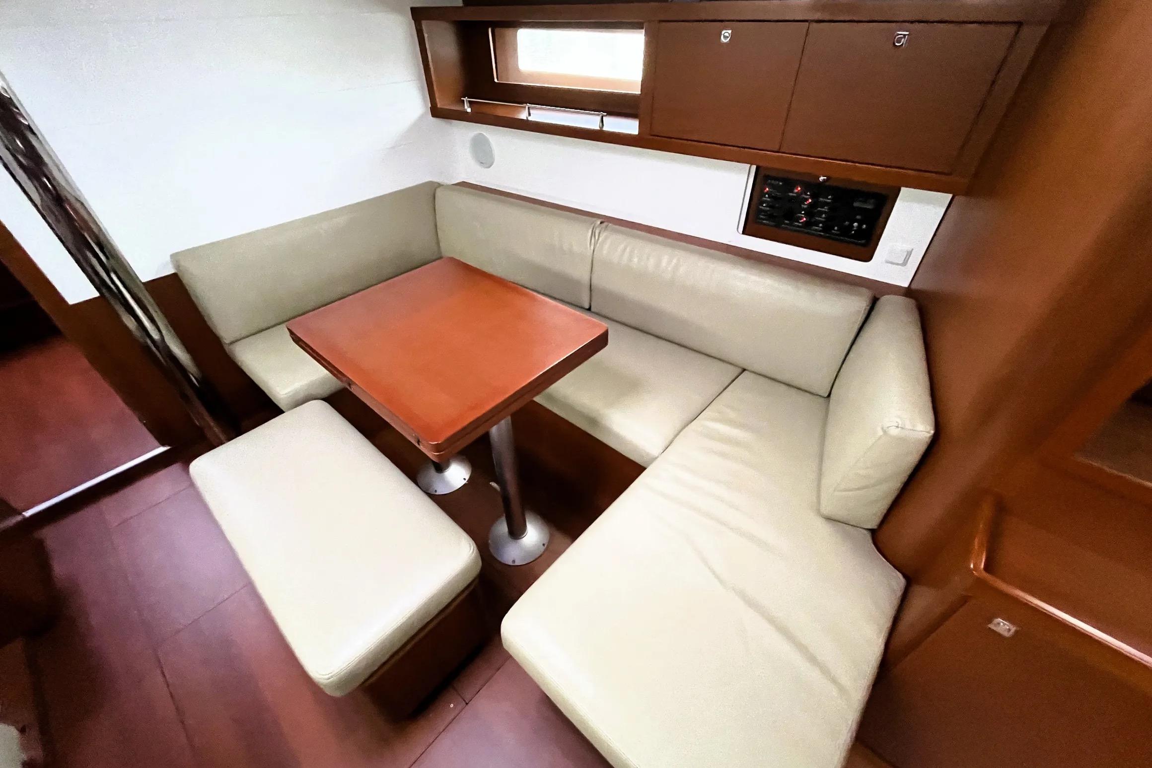 2018 Beneteau Oceanis 45 interior with beige seating and wooden table.