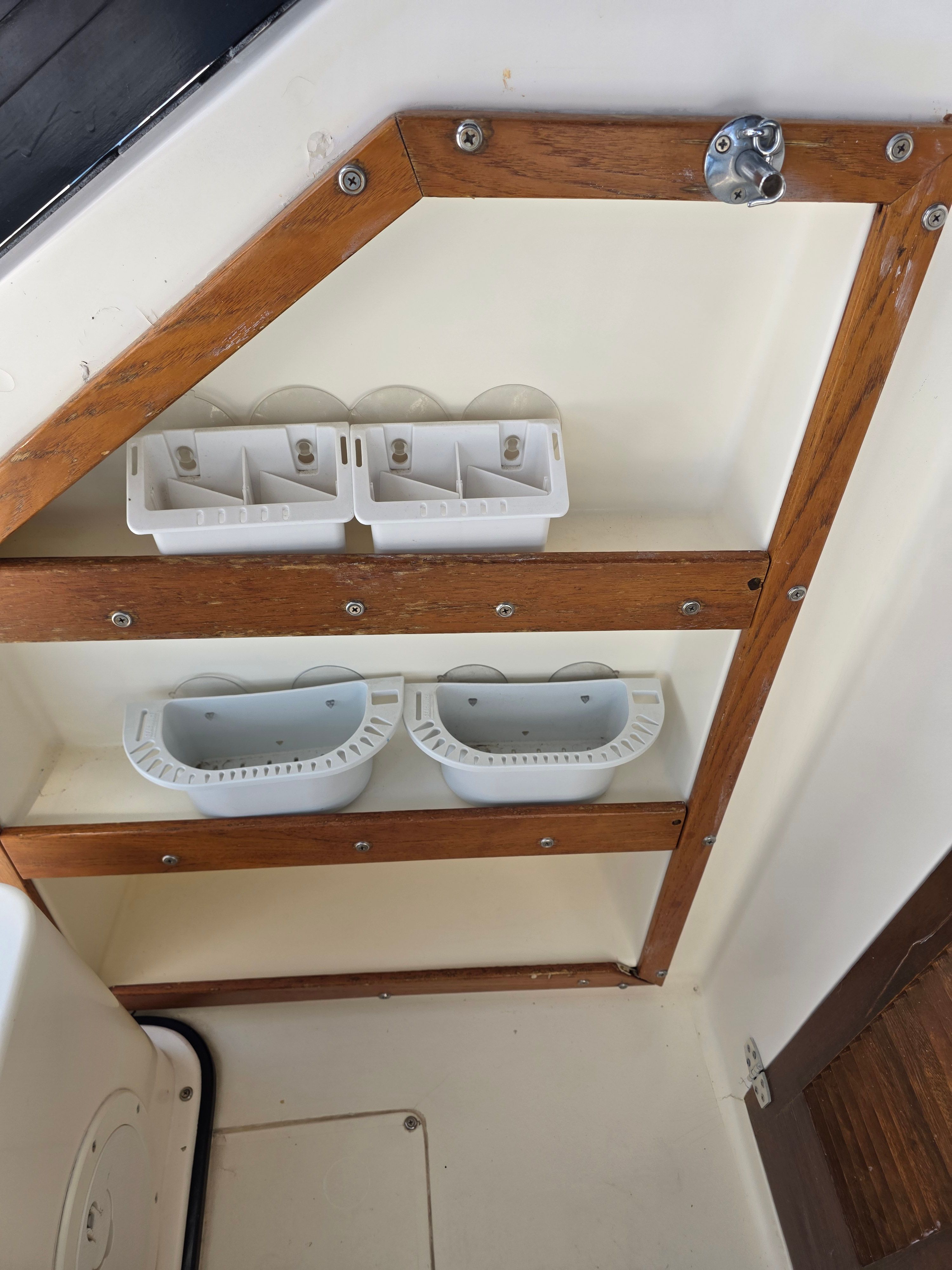 Interior of a 1987 Mako 248 WAC boat with wooden frame and storage bins.