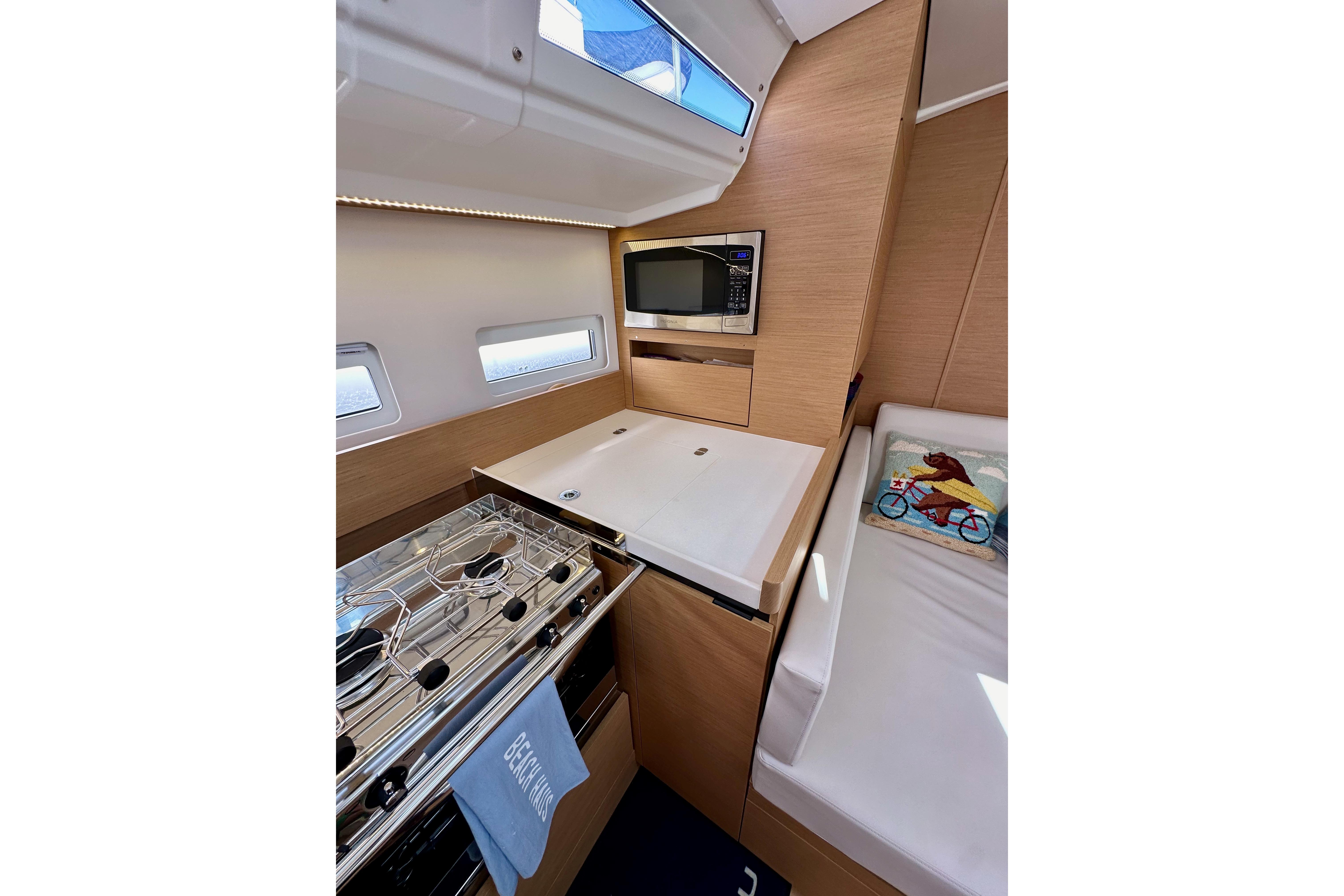 2024 Jeanneau Sun Odyssey 410 interior with modern kitchen and cozy seating area.