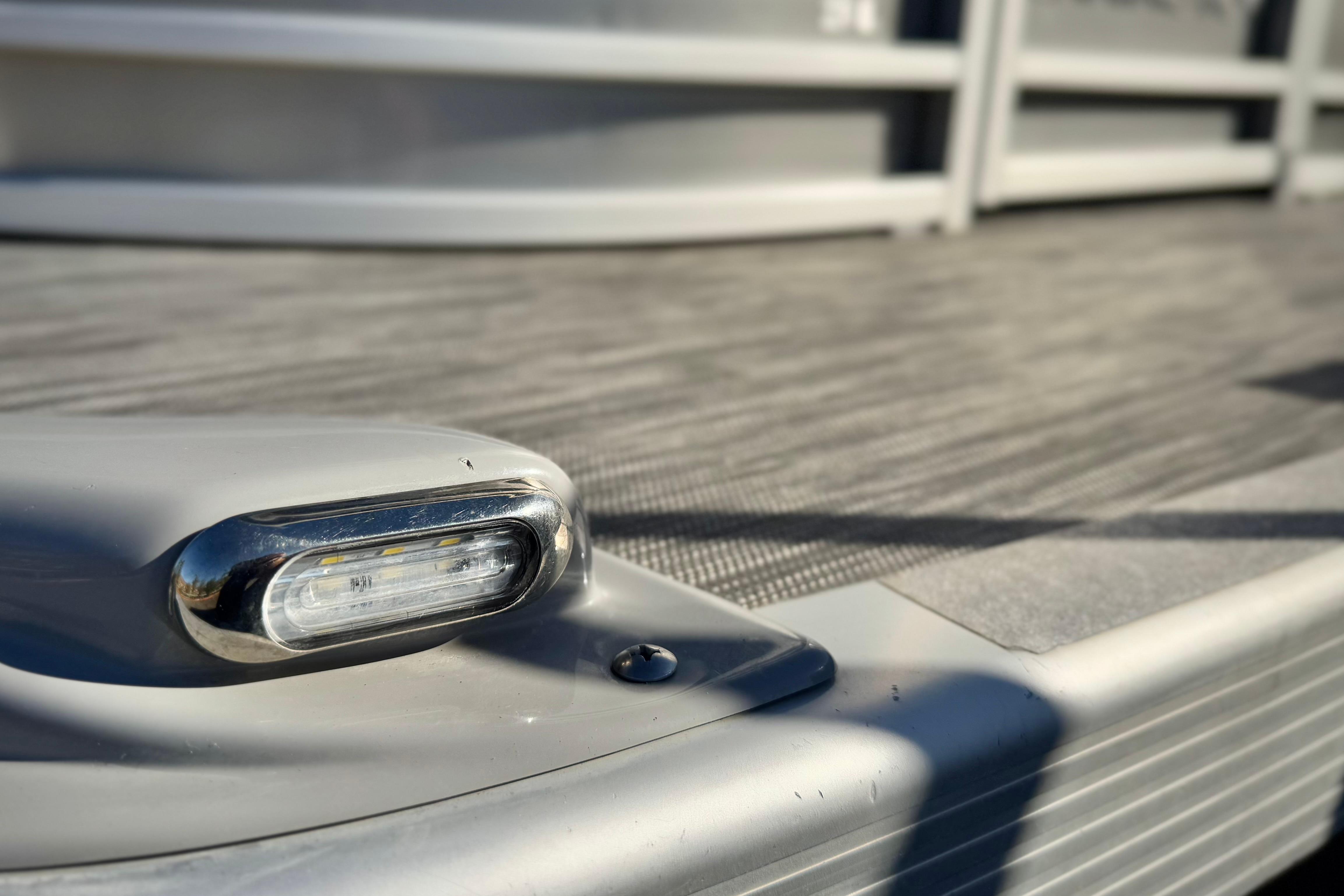 Close-up of a 2021 Bennington 23LSR boat deck with a sleek chrome light fixture.