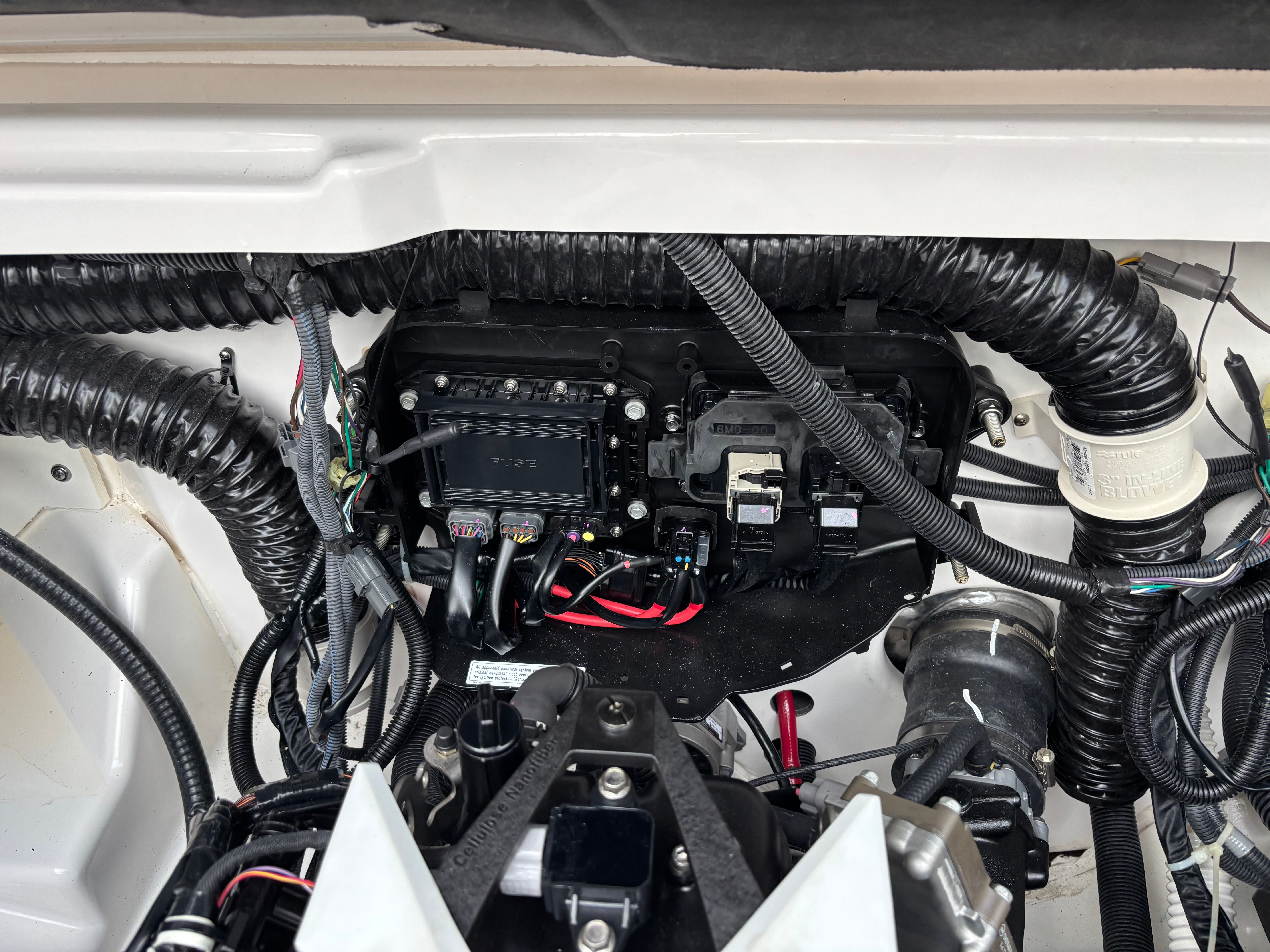 Engine compartment of a Yamaha AR250 boat with wires and components.