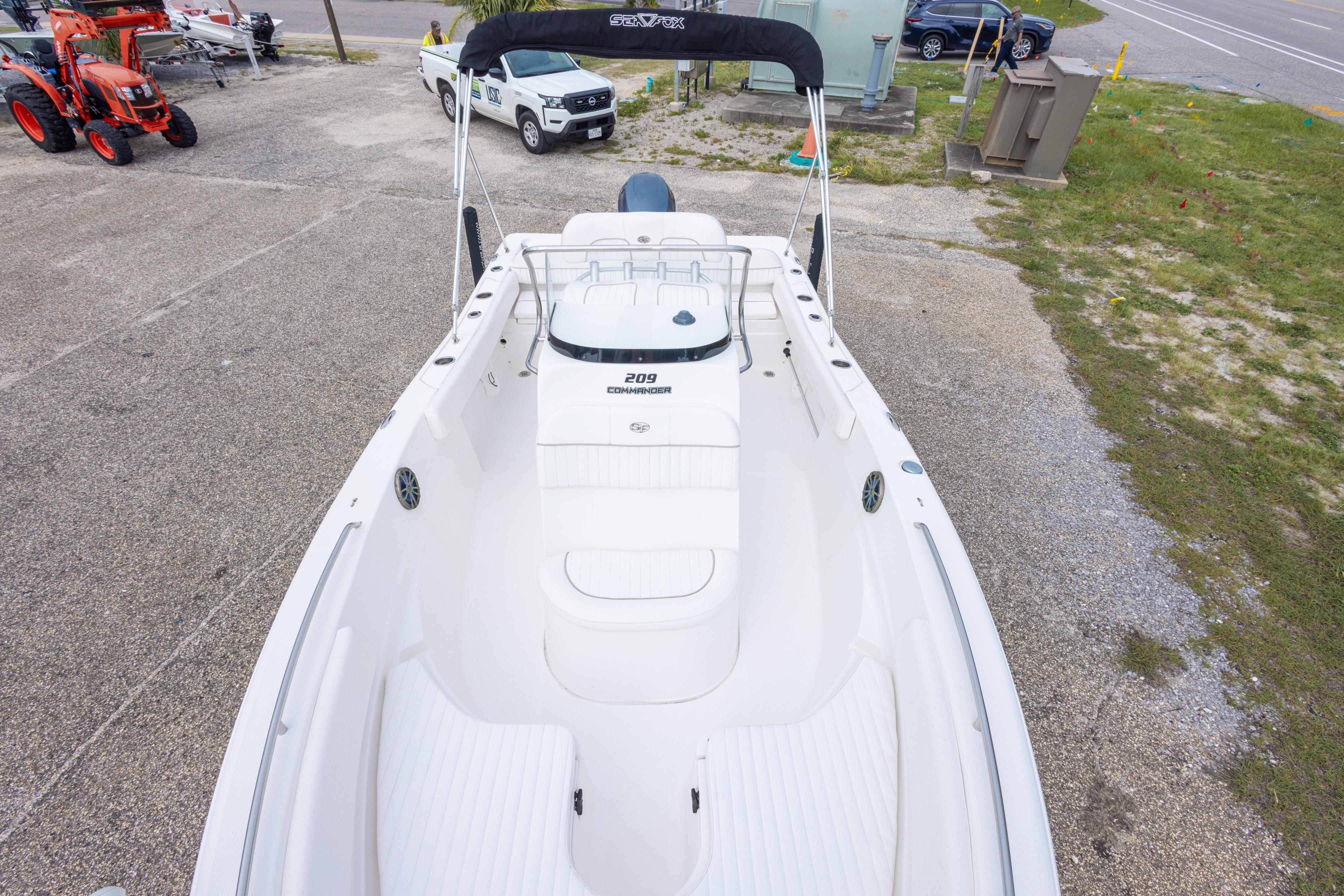 2014 Sea Fox 209 Commander boat, white interior, parked on gravel near grass.