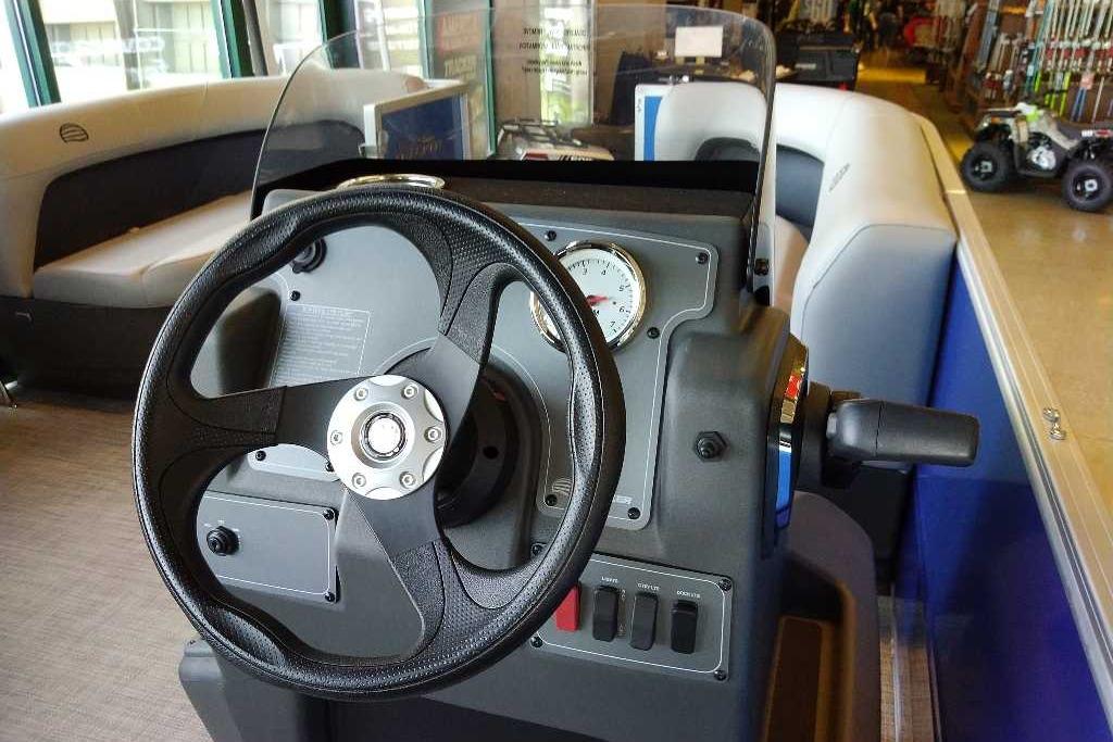 2026 Sun Tracker Party Barge 16 DLX steering console with gauges and controls.