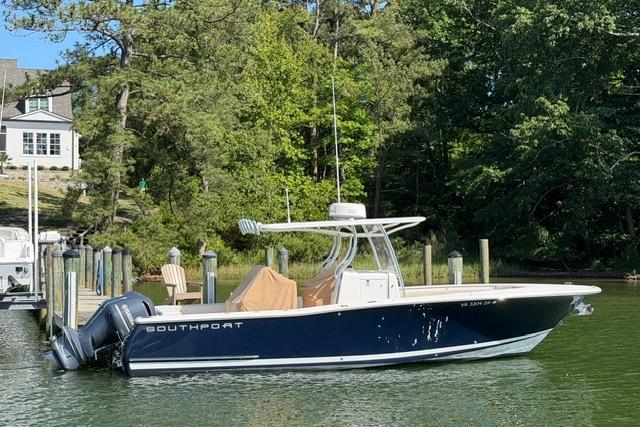 2014 Southport 29 FE boat docked on a serene lake with lush greenery.