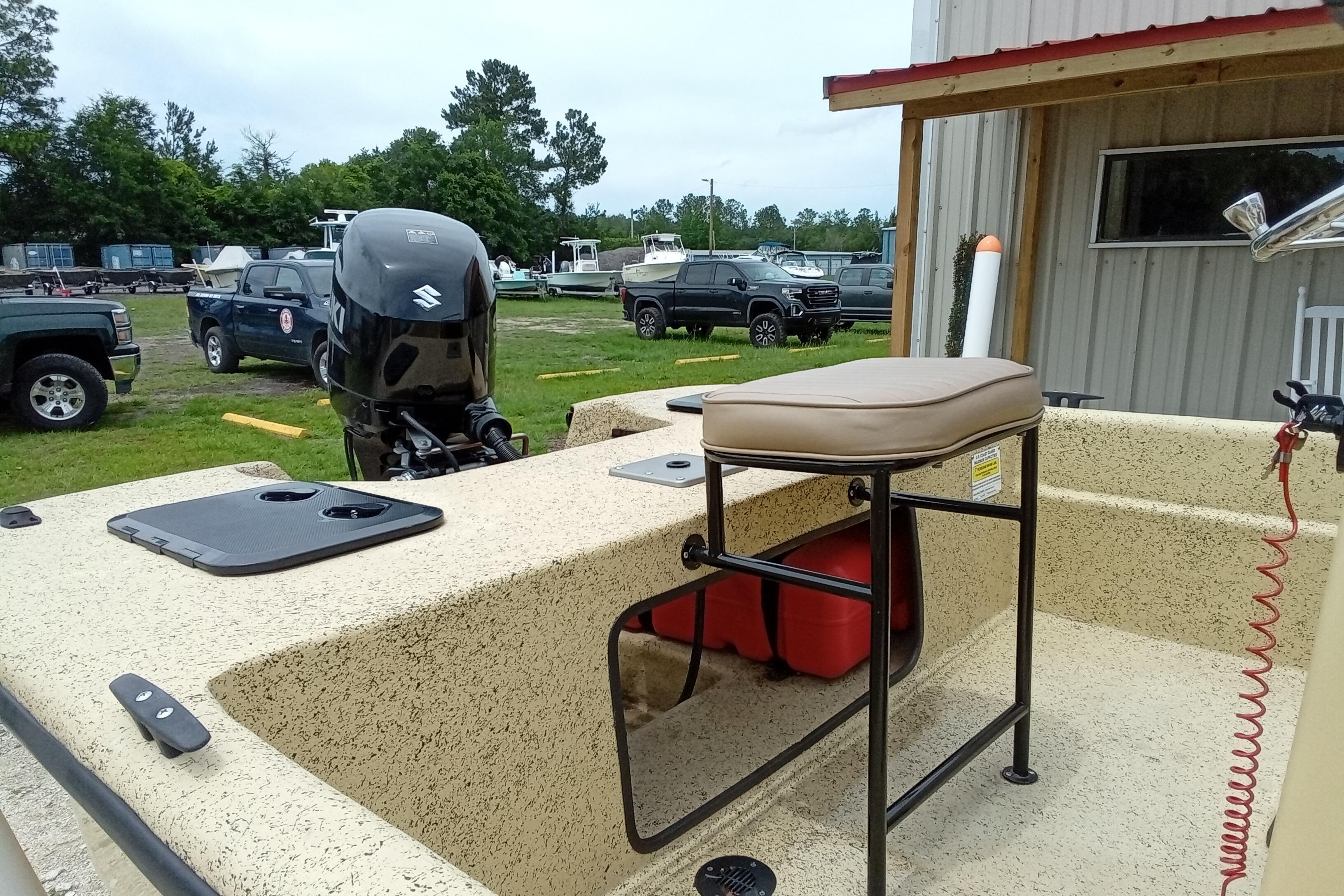 2025 Fibercraft F17 boat with Suzuki outboard motor, parked outdoors near a building.