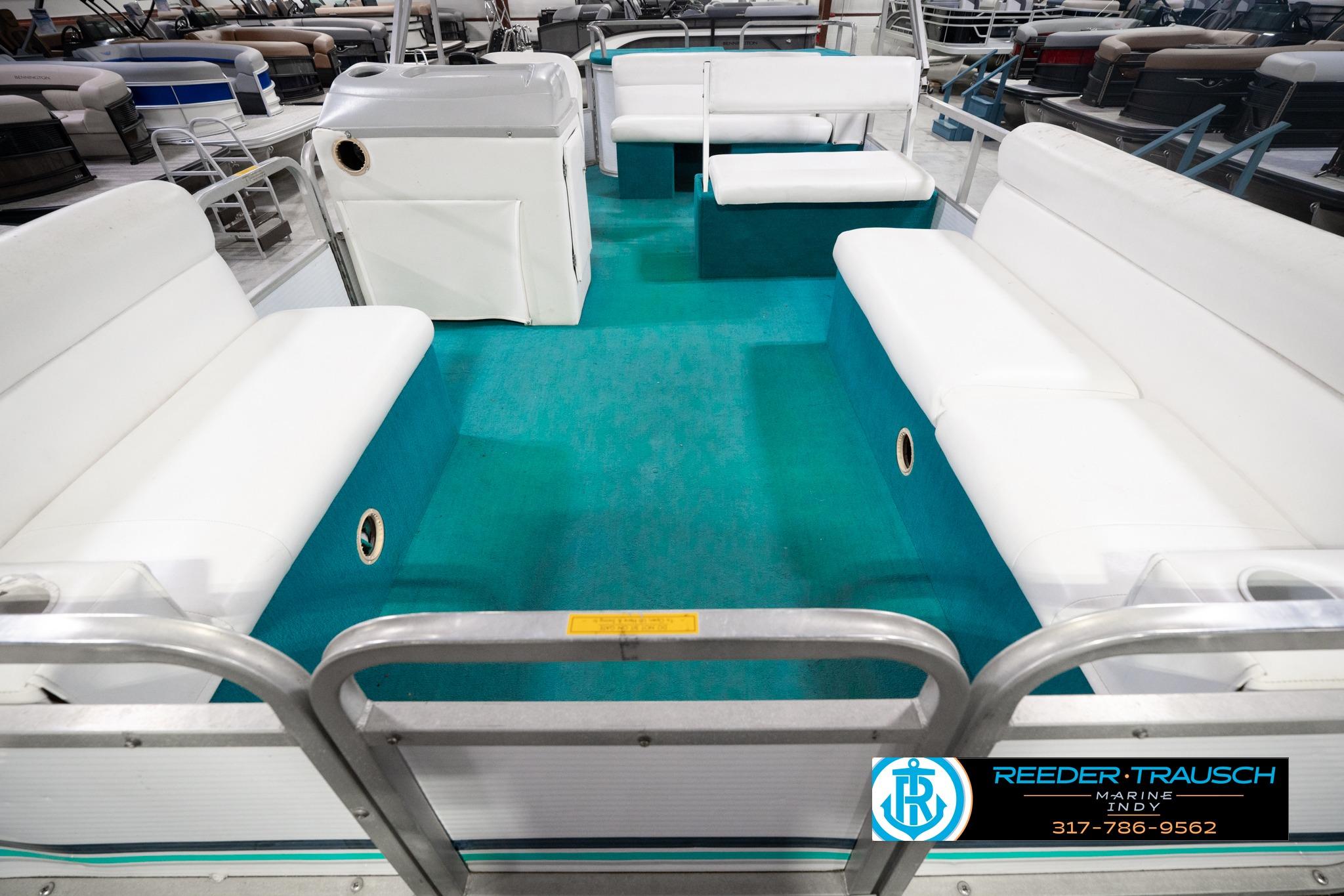 1992 Godfrey Sweetwater pontoon boat interior with white seating and teal flooring.