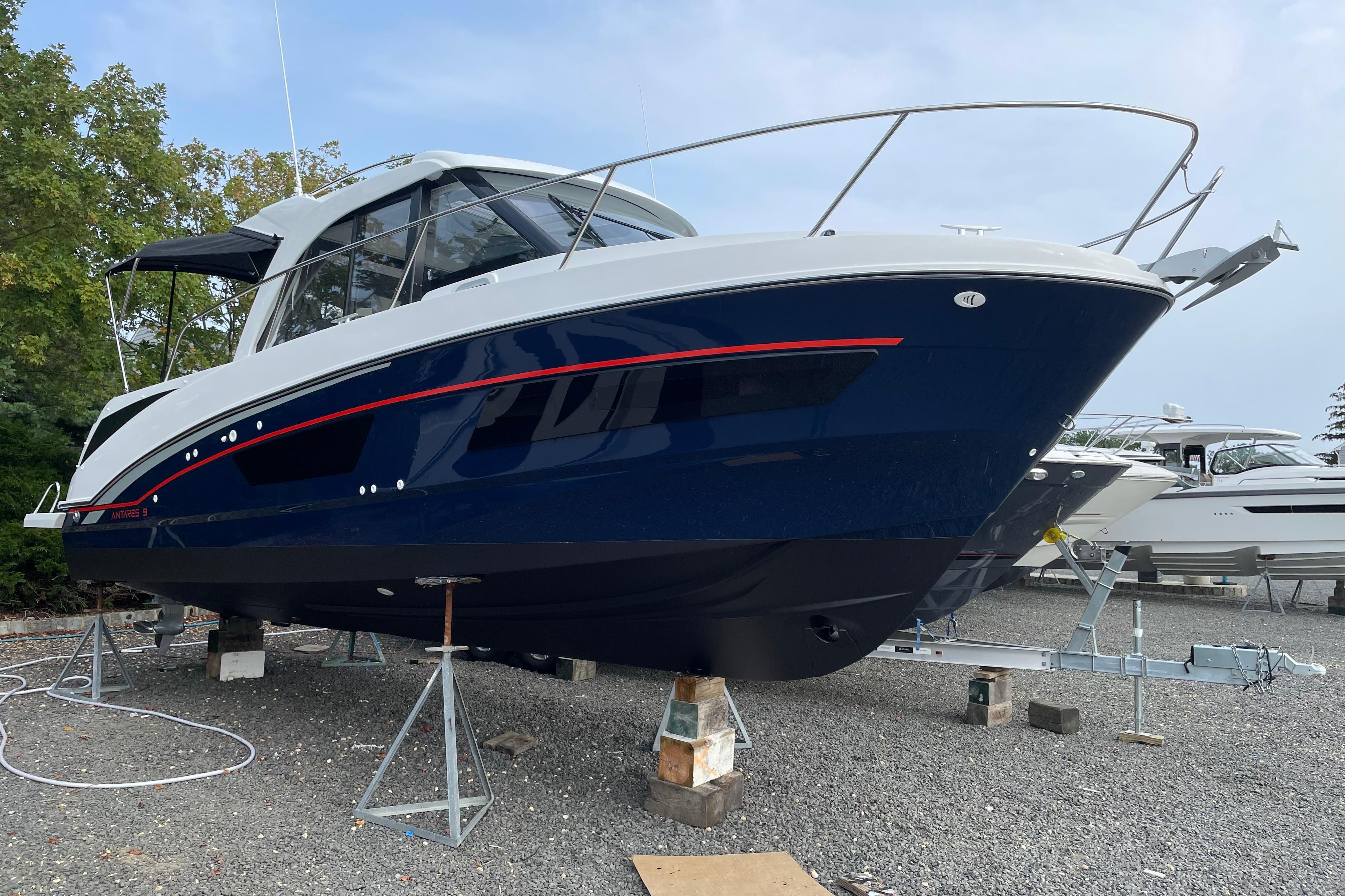 2024 Beneteau Antares 9 boat on stands, blue hull, sleek design, outdoor setting.