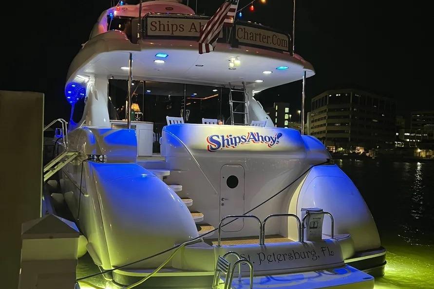 2004 Lazzara SC Motor Yacht docked at night, illuminated with blue lights.