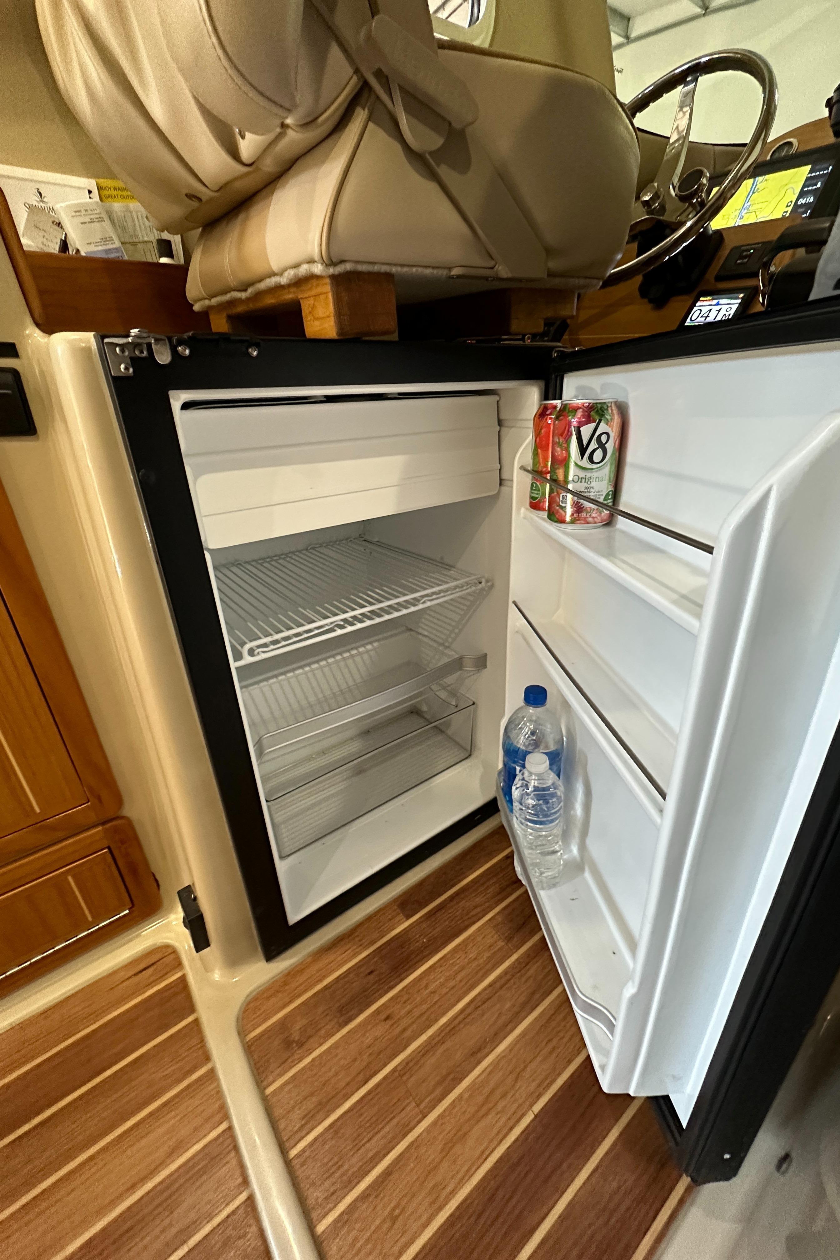Small fridge in Aspen C100 boat, open with drinks inside.