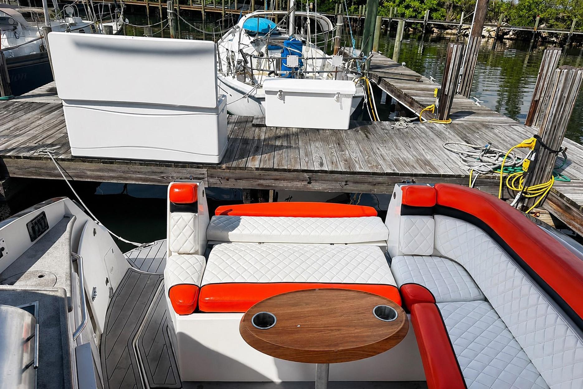 2012 Rinker 310 Express Cruiser LE with red and white seating at a dock.