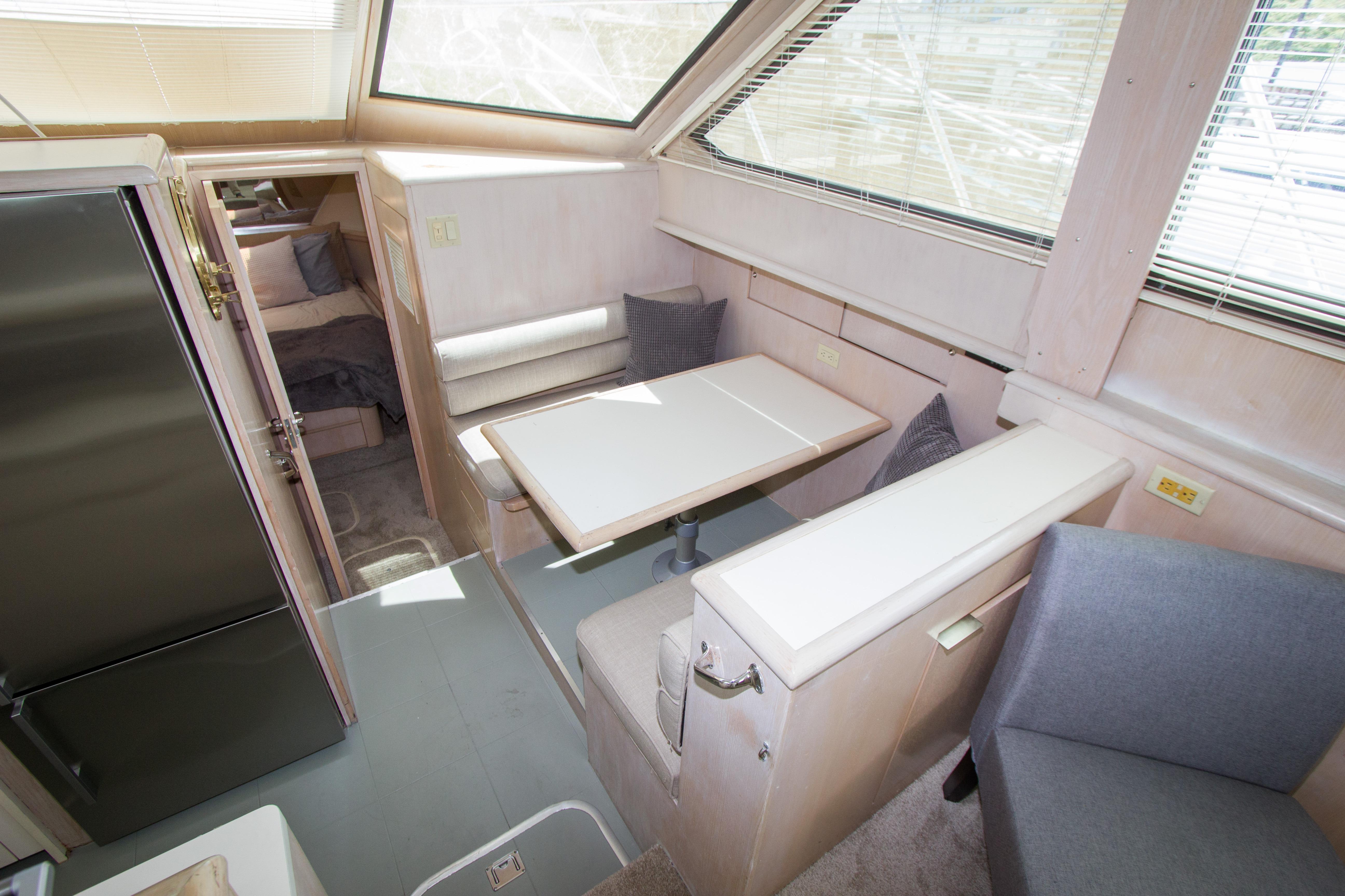 Interior of 1994 Hatteras 52 Cockpit Motor Yacht with dining area and seating.