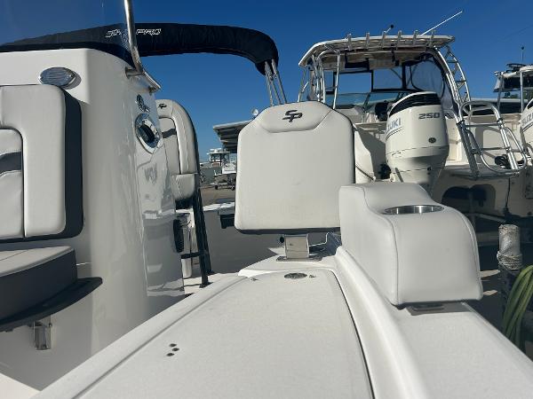 2025 Sea Pro 210 Bay boat interior with seating and console, docked alongside other boats.