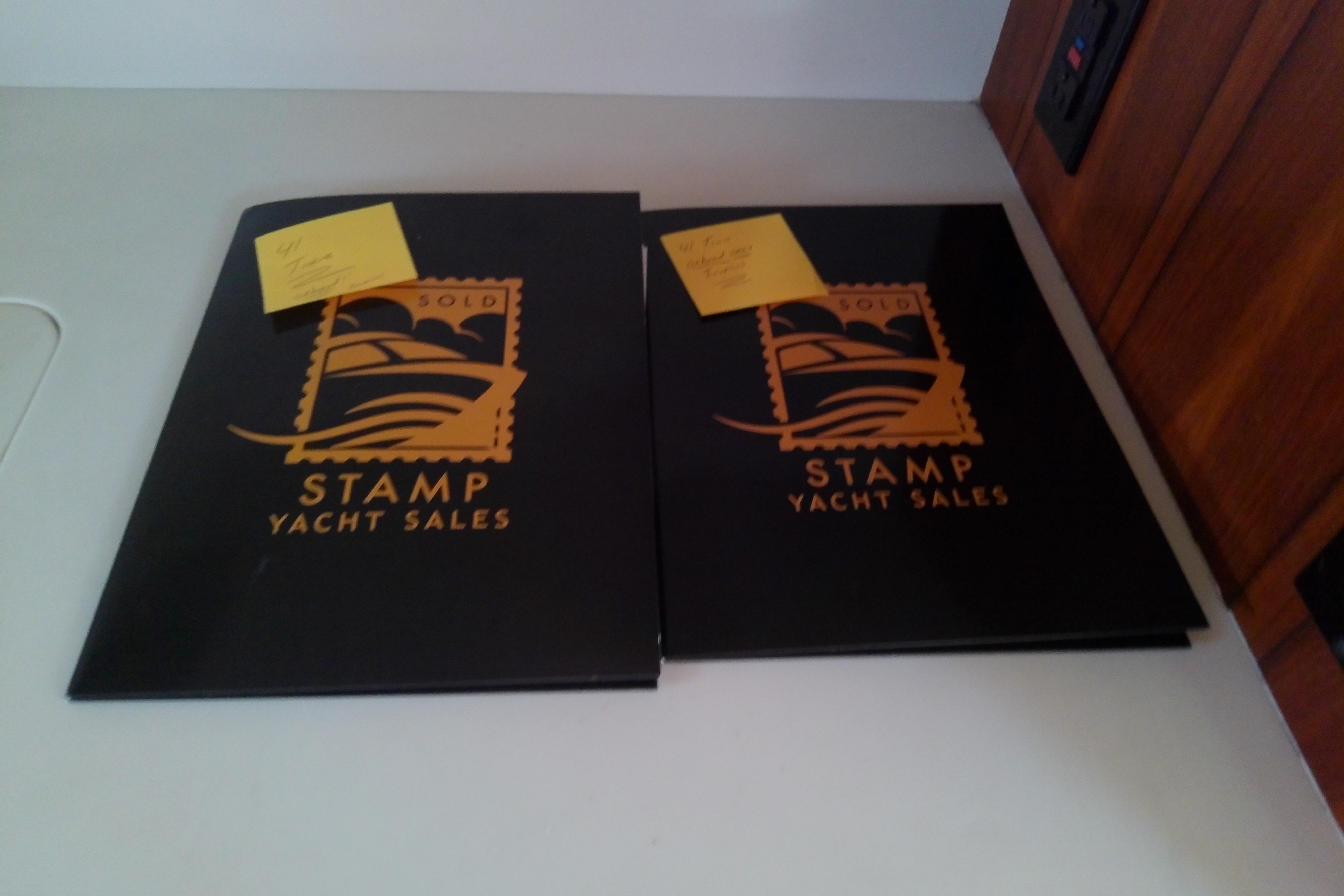 Two Stamp Yacht Sales folders on a table, featuring Tiara Yachts 4100 Open, 2000 model.