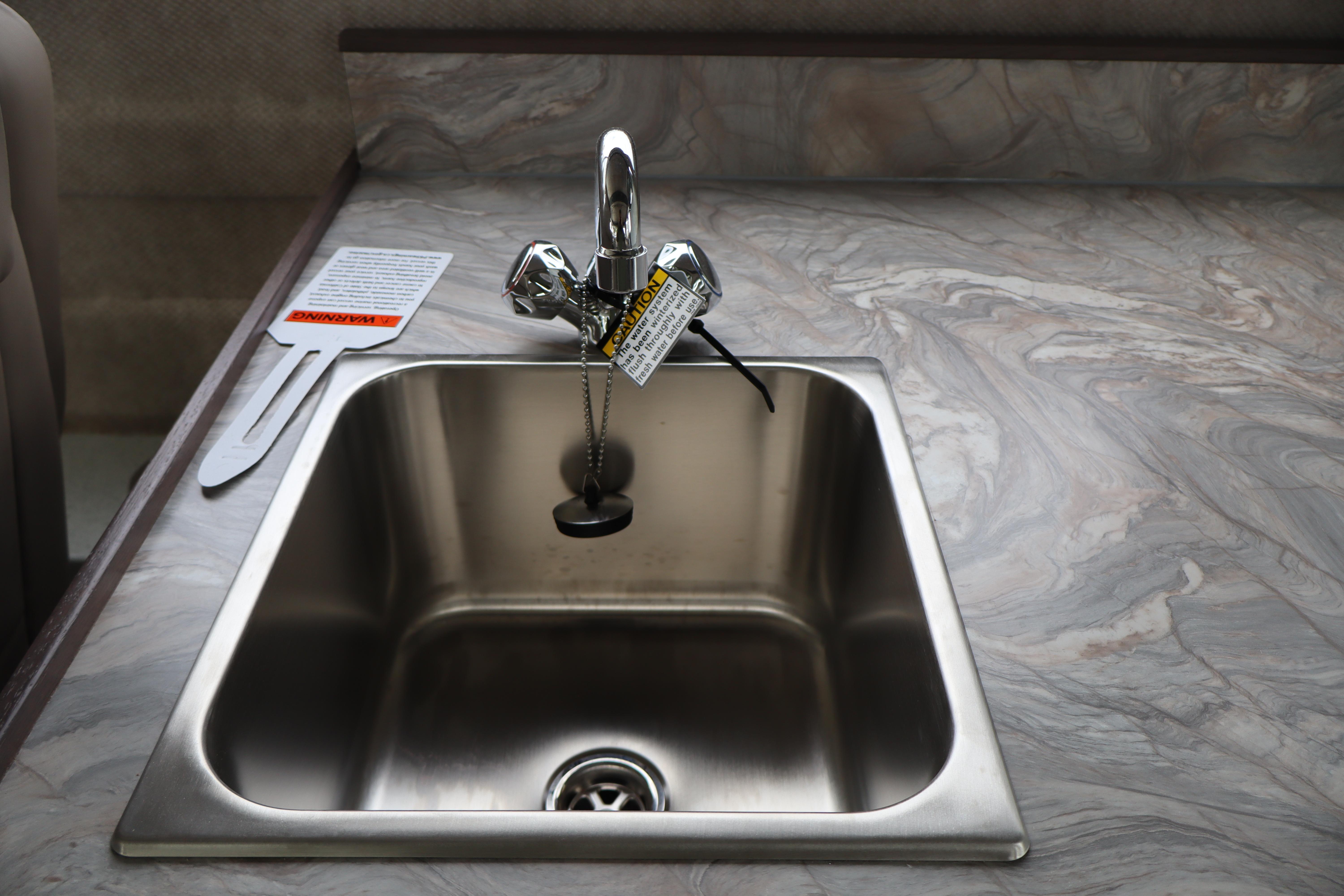 Stainless steel sink with faucet in 2026 KingFisher 3025 XRS boat kitchen.