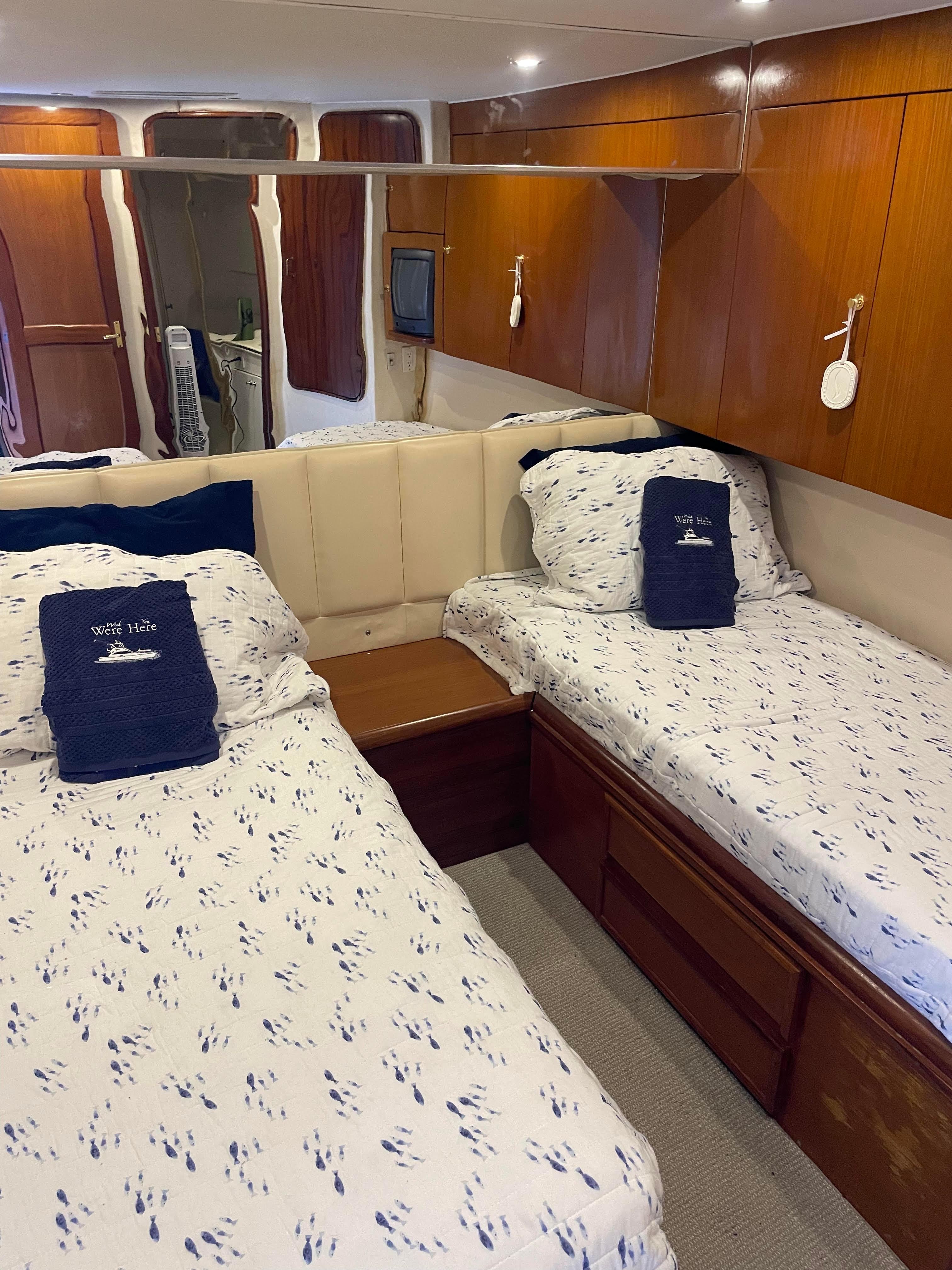 Interior cabin of 1997 Ocean Yachts SS Sport Fisherman with twin beds and wooden cabinetry.