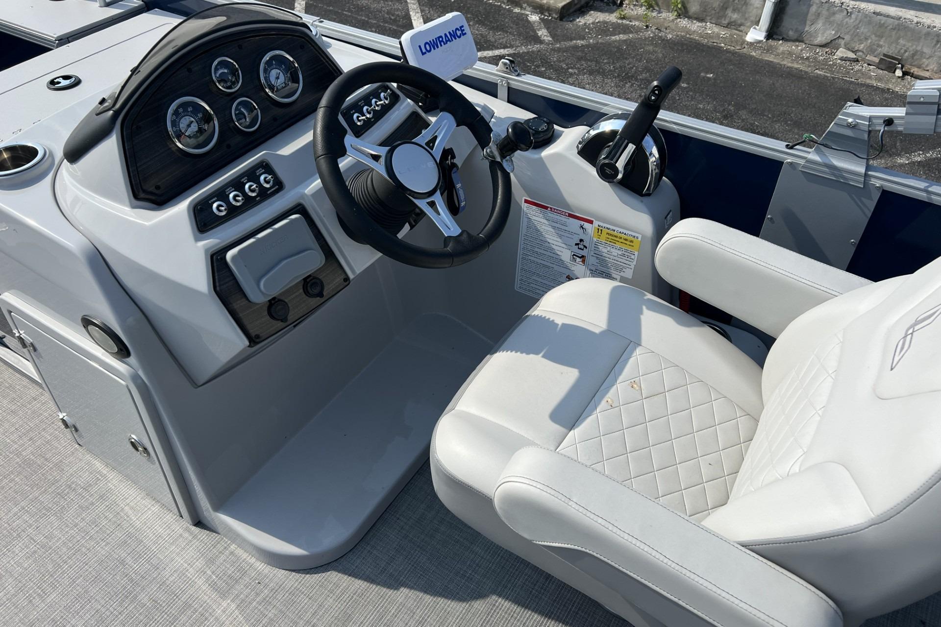 2024 Lowe SF 214 Sport Fish boat cockpit with steering wheel and control panel.