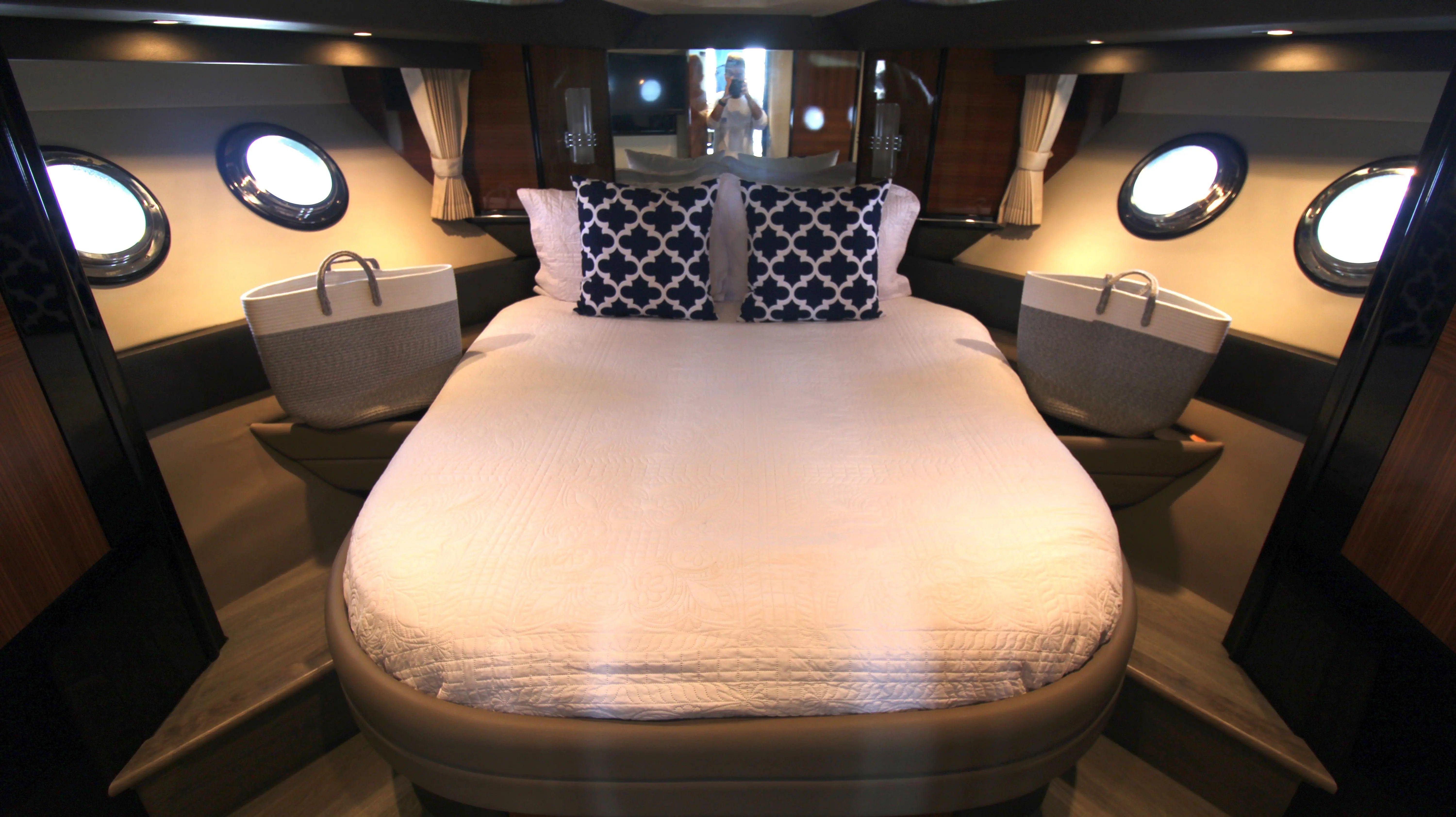 Luxurious yacht bedroom with a large bed and round windows.