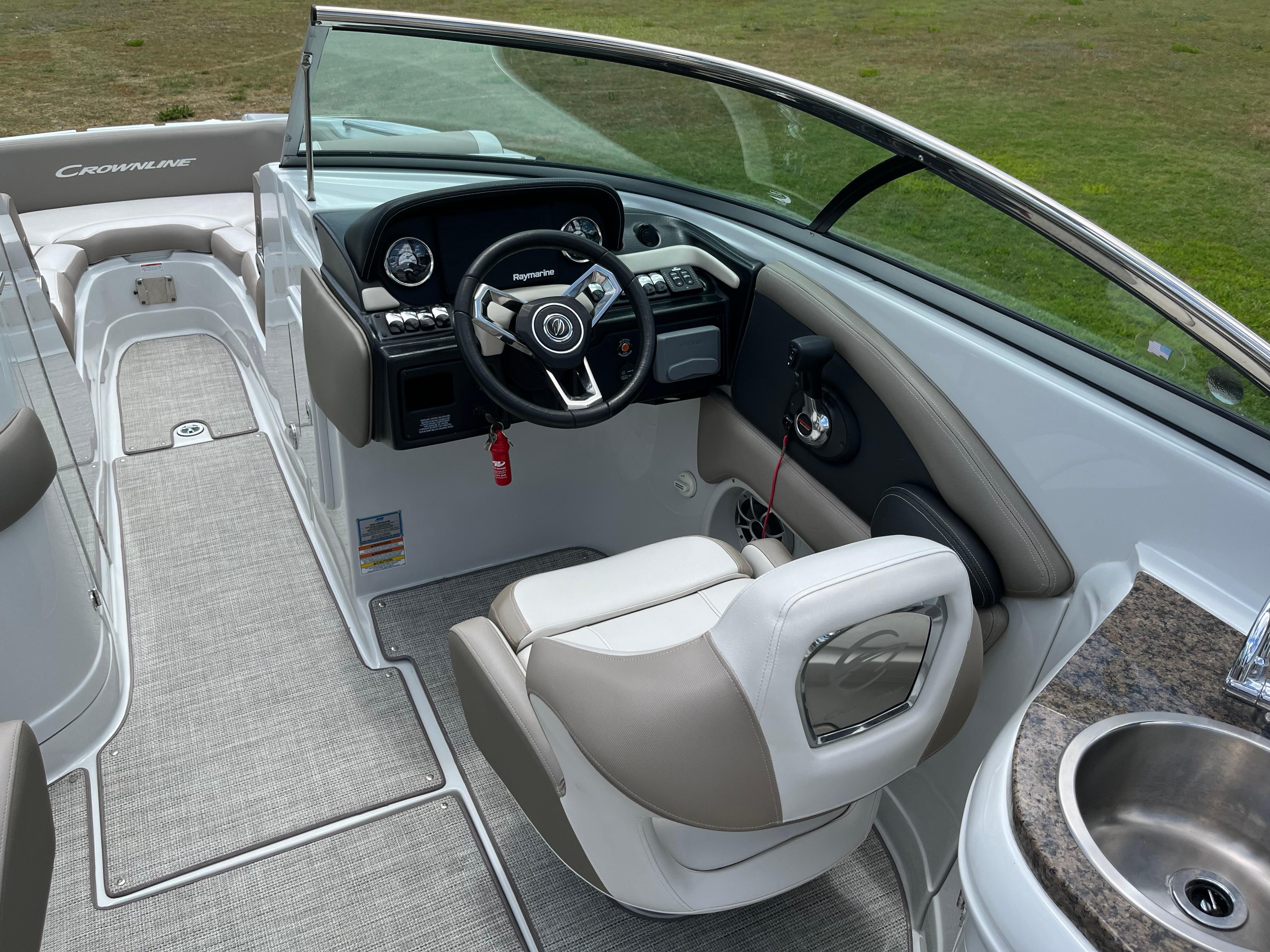 The image shows the cockpit of a 2019 Crownline E 285 boat with a sleek helm area.