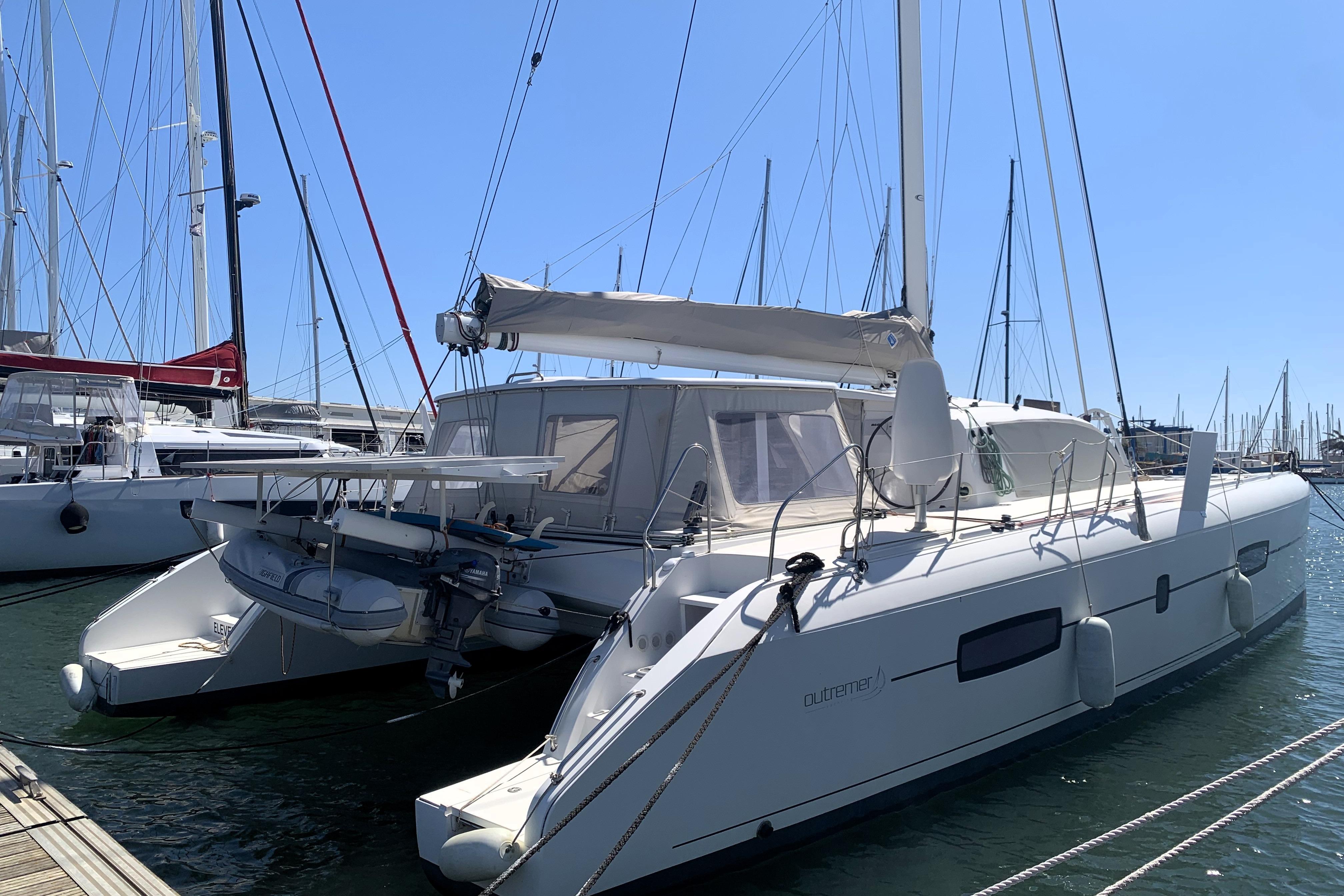 2015 Outremer 51 catamaran docked at marina, sunny day, sailboats in background.