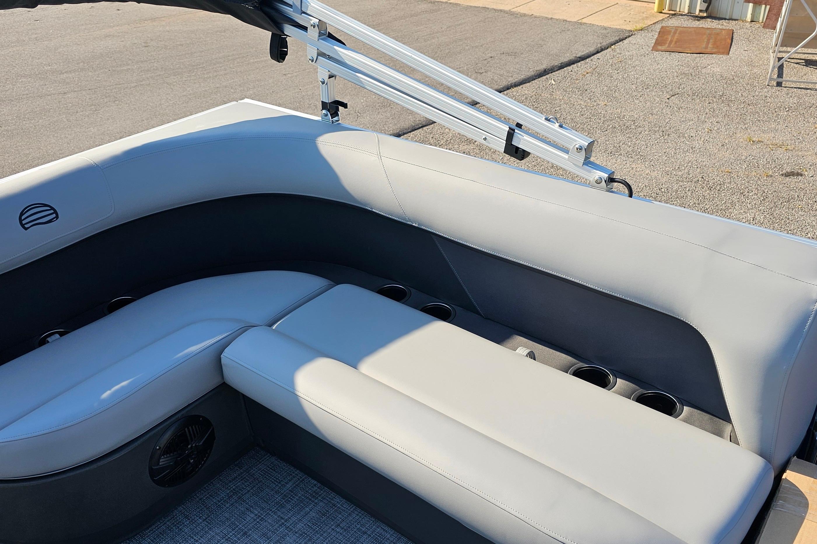 2026 Sun Tracker Party Barge 16 DLX interior with gray seating and cup holders.