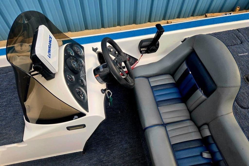1996 Champion 181 SX boat cockpit with steering wheel, gauges, and blue-gray seating.