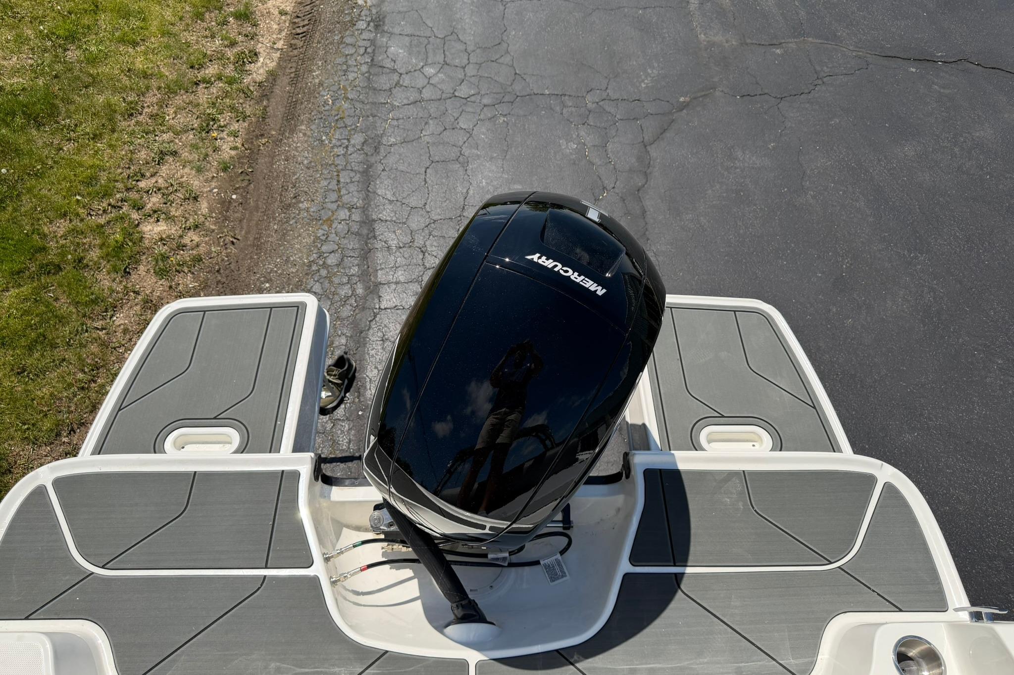 Top view of 2026 Bayliner D20 boat with Mercury engine on pavement.