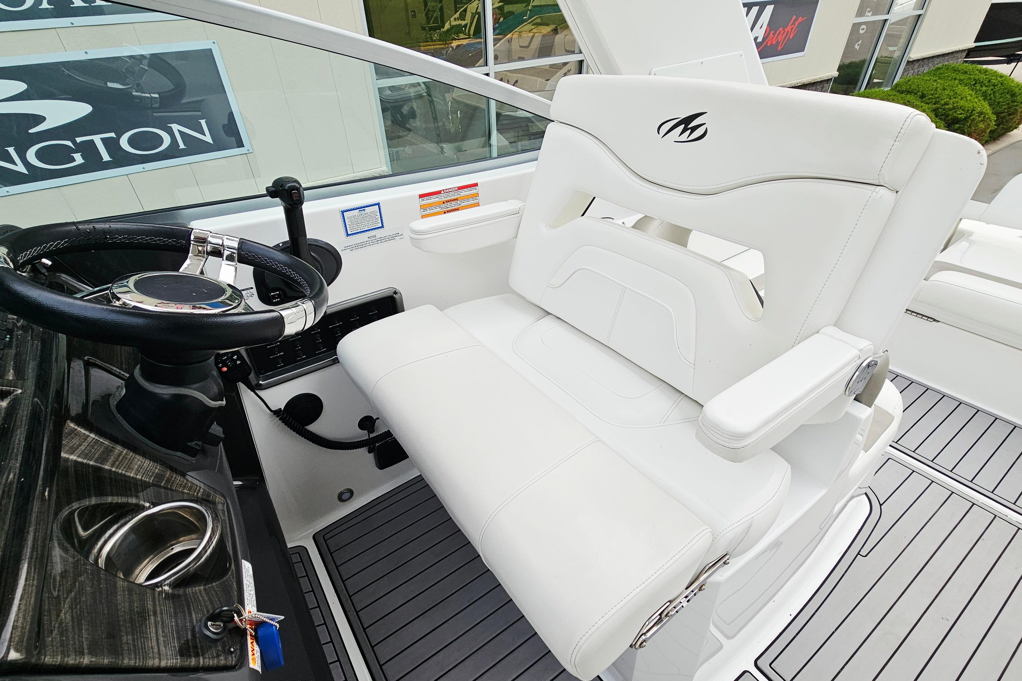 Helm seat and steering wheel of 2016 Monterey 295 Sport Yacht, featuring sleek design and controls.