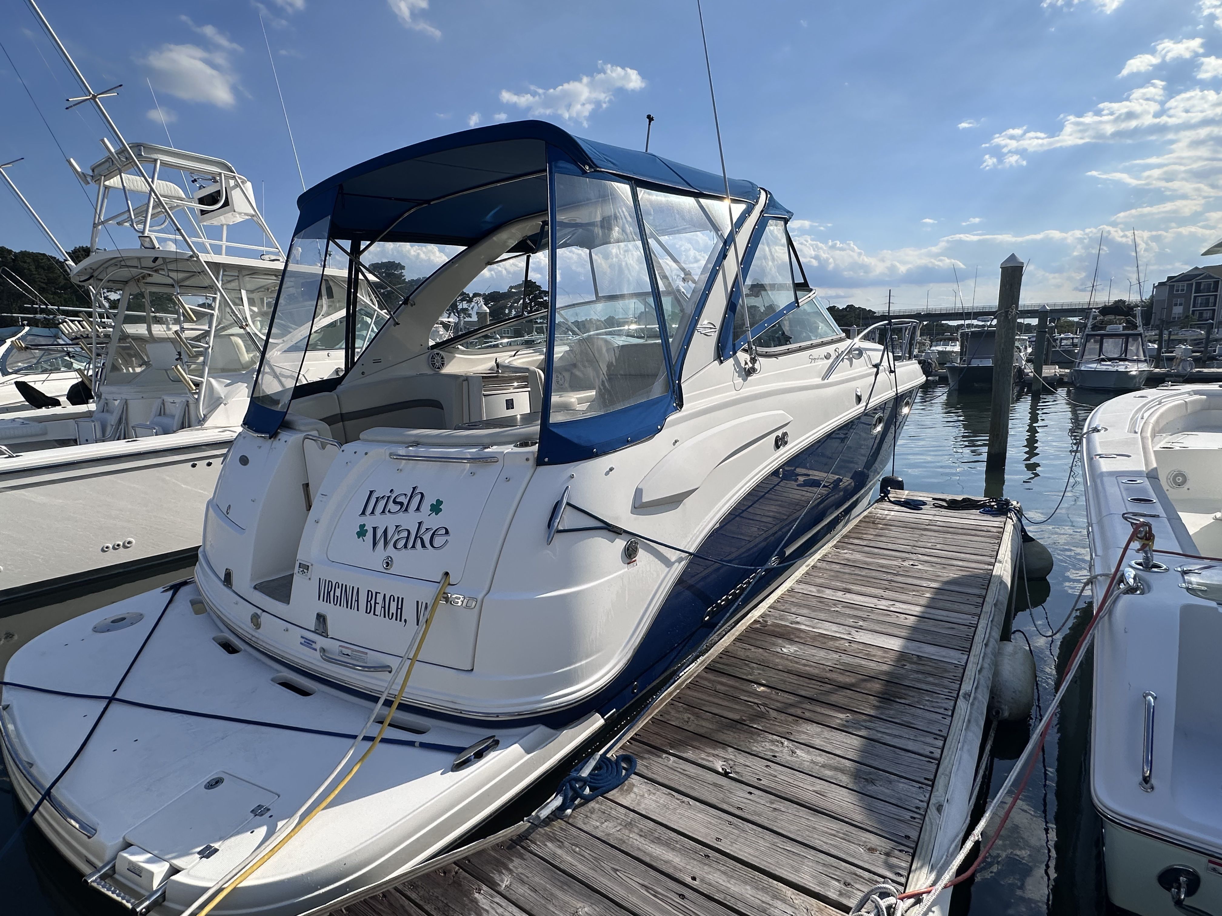 2008 Chaparral Signature 330 docked, featuring a blue canopy and "Irish Wake" on the stern.