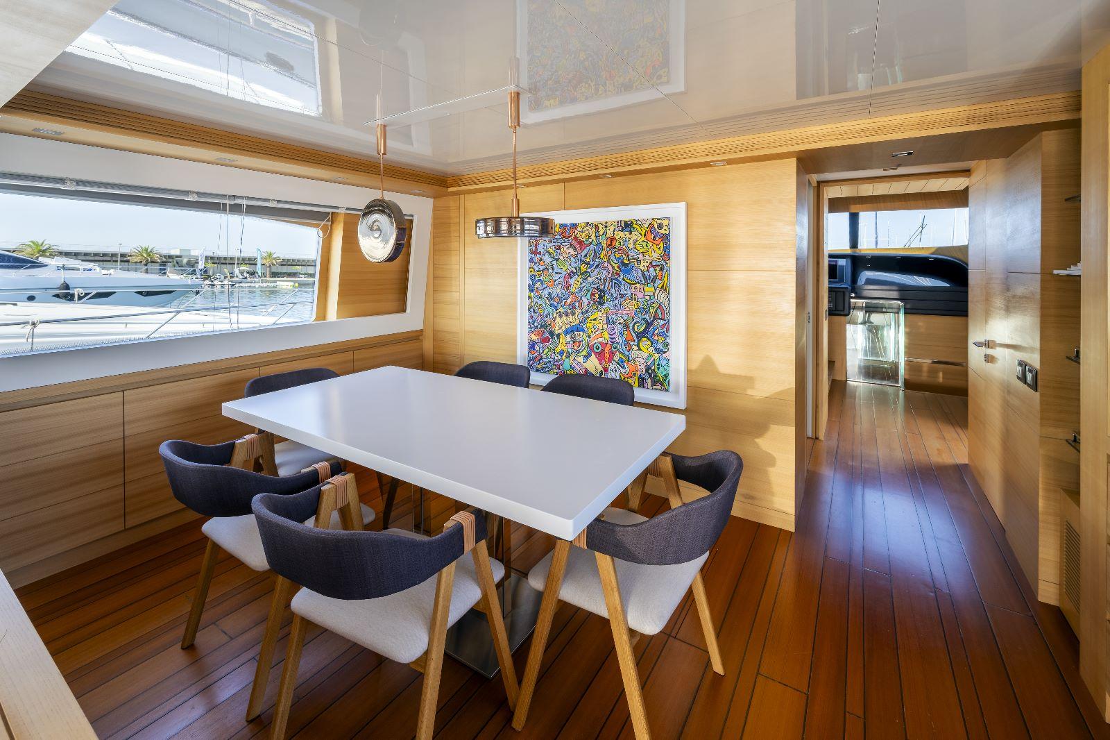 Luxurious dining area on 2011 Maiora 27 yacht with modern decor and vibrant artwork.
