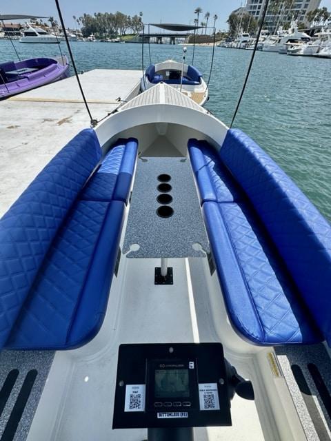 2023 Vision Marine Technologies Fantail 217 boat with blue seating, docked by the water.