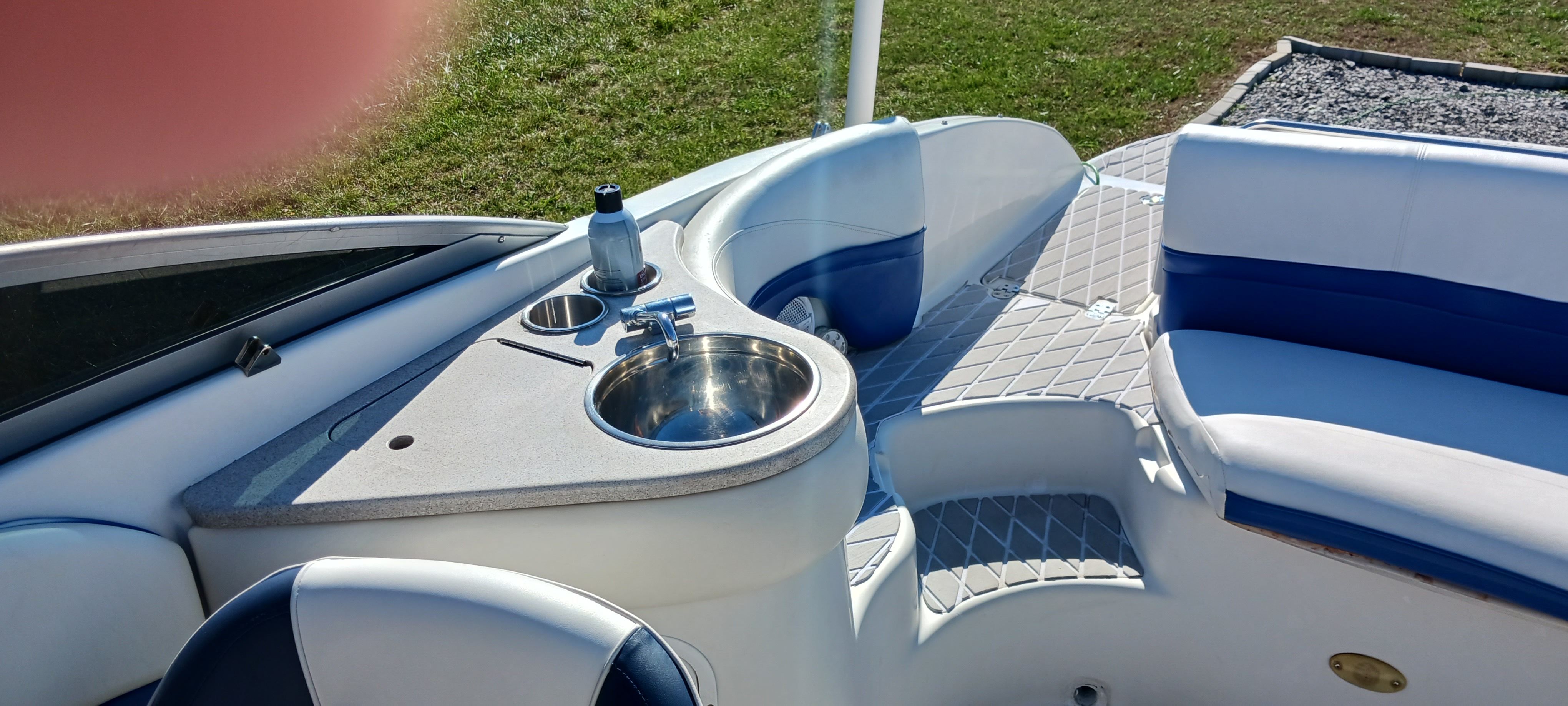 2003 Four Winns 205 Sundowner boat interior with seating and sink.