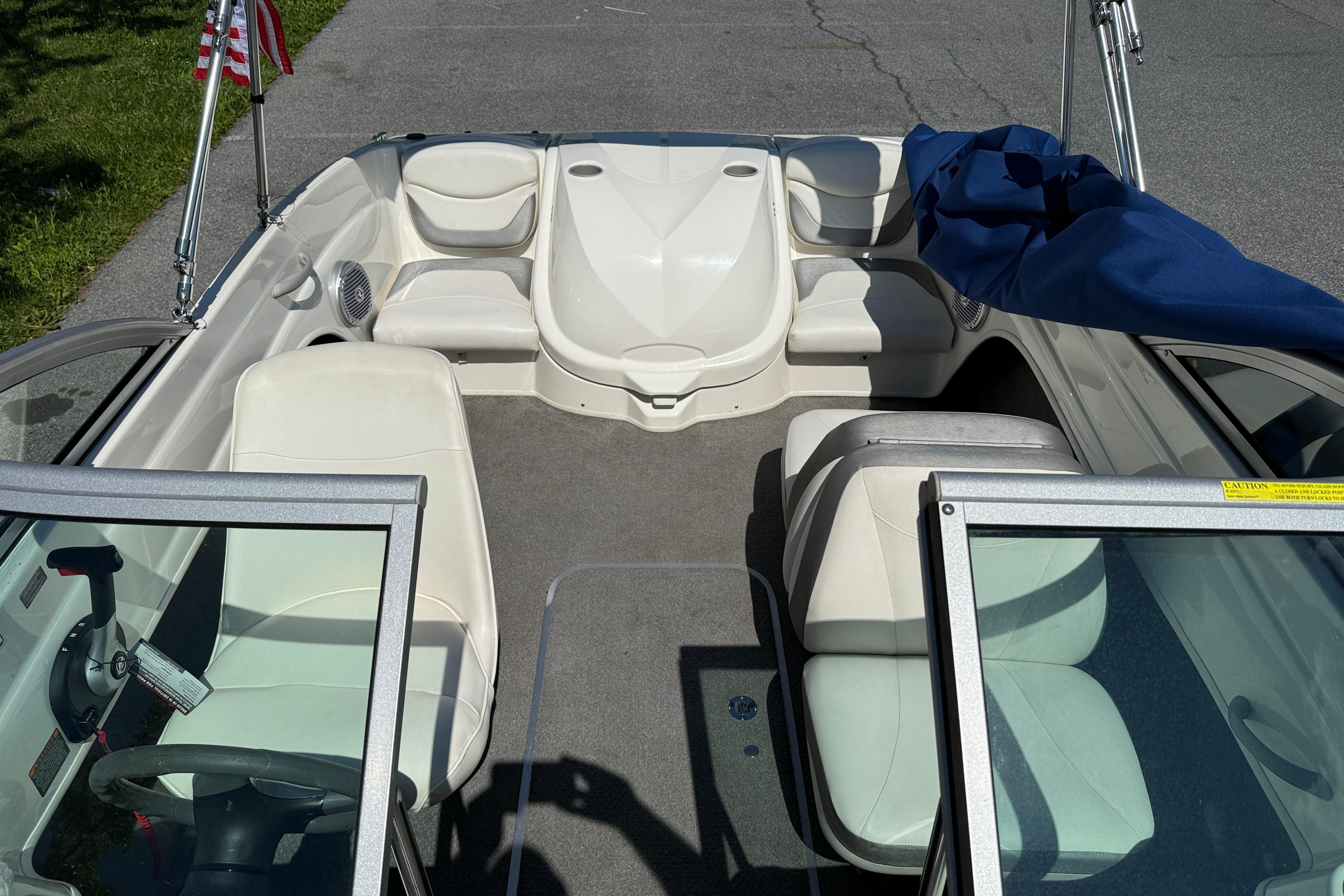 2009 Bayliner 175 boat interior with white seating and steering wheel, parked on pavement.