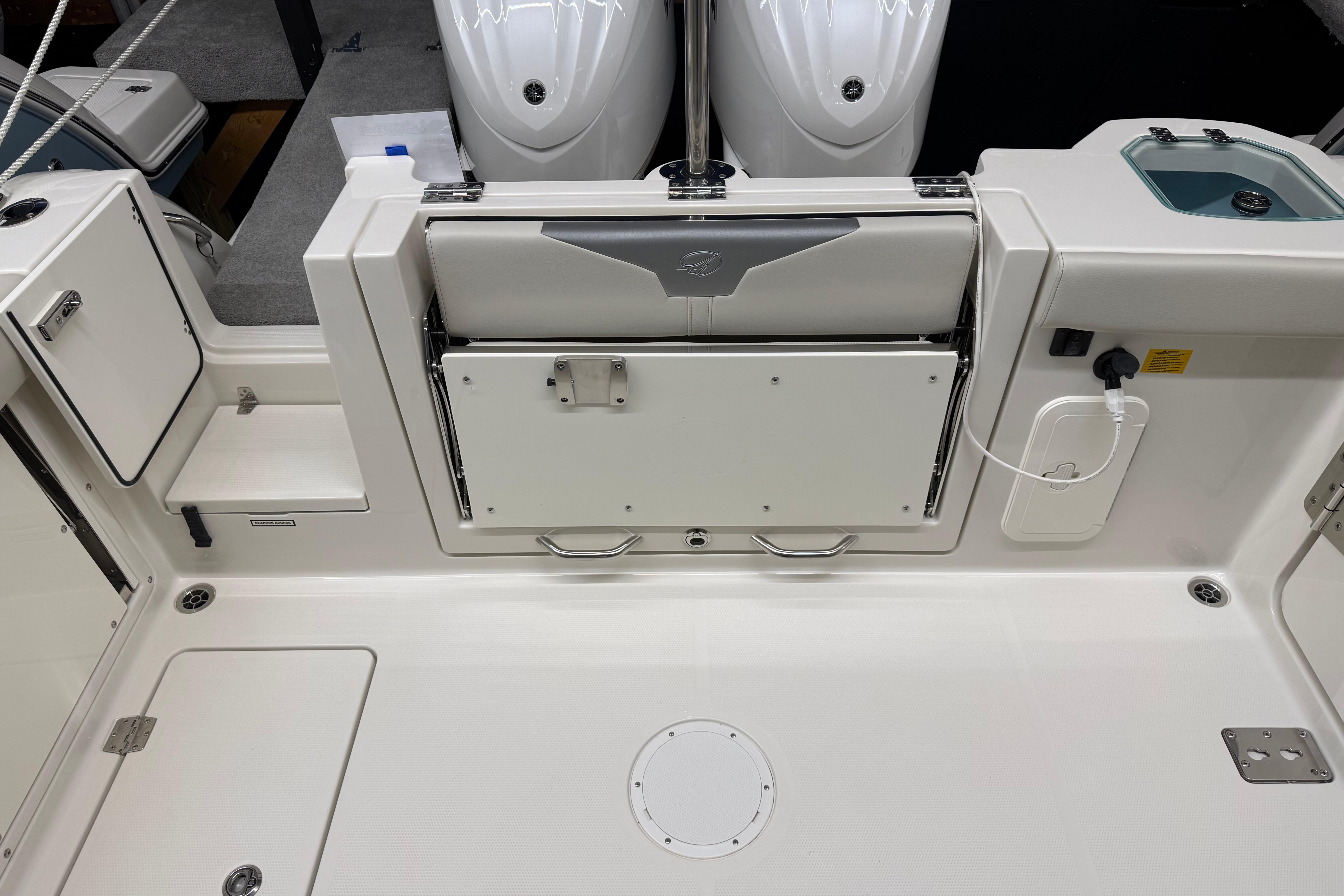 2026 Sailfish 276 DC boat interior with foldable seat and storage compartments.