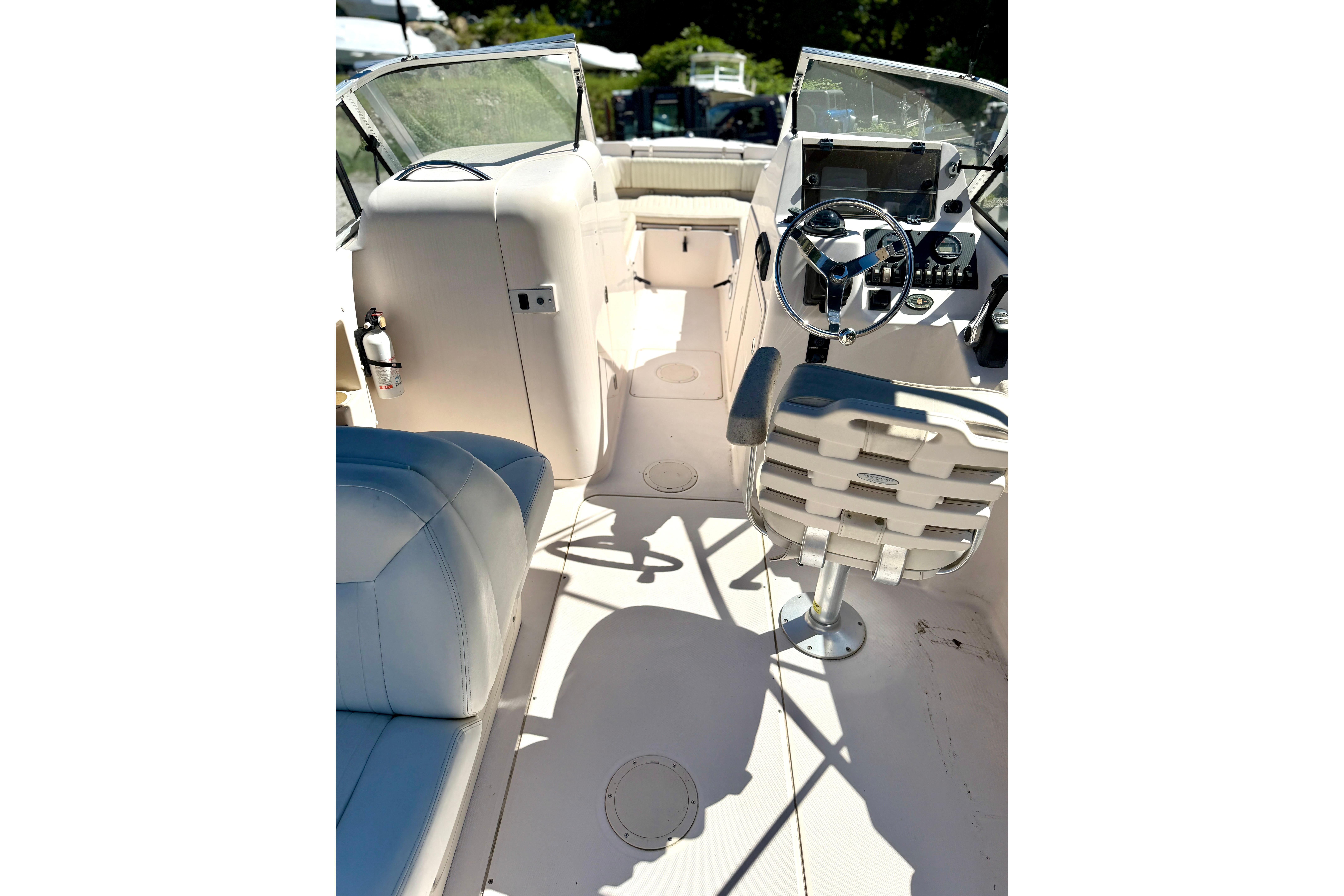 Interior view of 2005 Grady-White Freedom 225 boat, featuring steering wheel and seating.